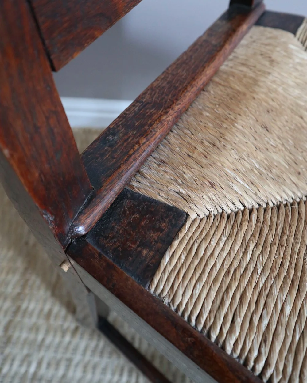 Pair of sculptural rustic oak ladder back dining chairs with rush seats, circa 1930s.