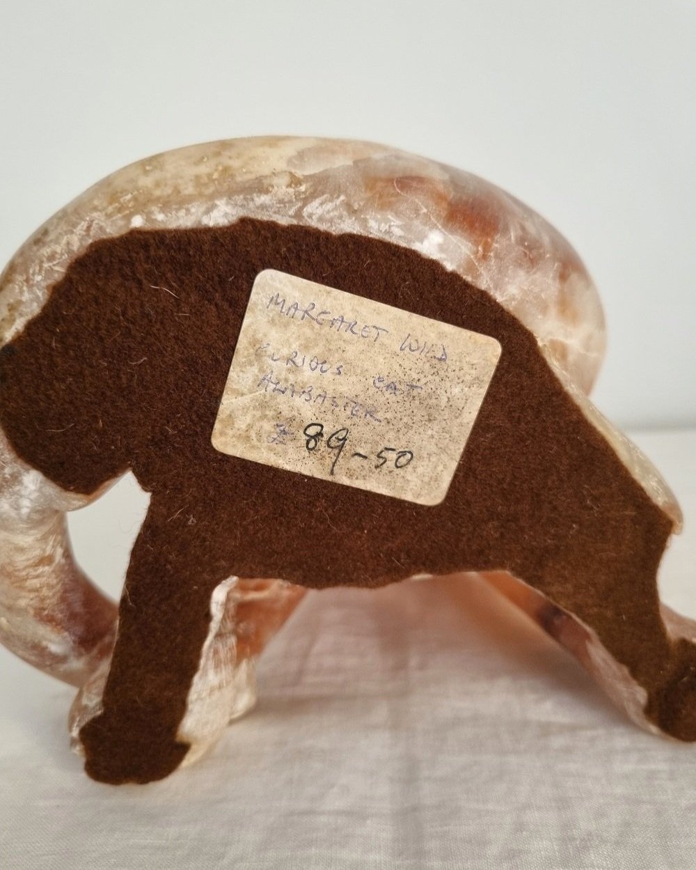 Vintage, heavy hand carved soft pink alabaster cat with striking natural grain and smooth lines.