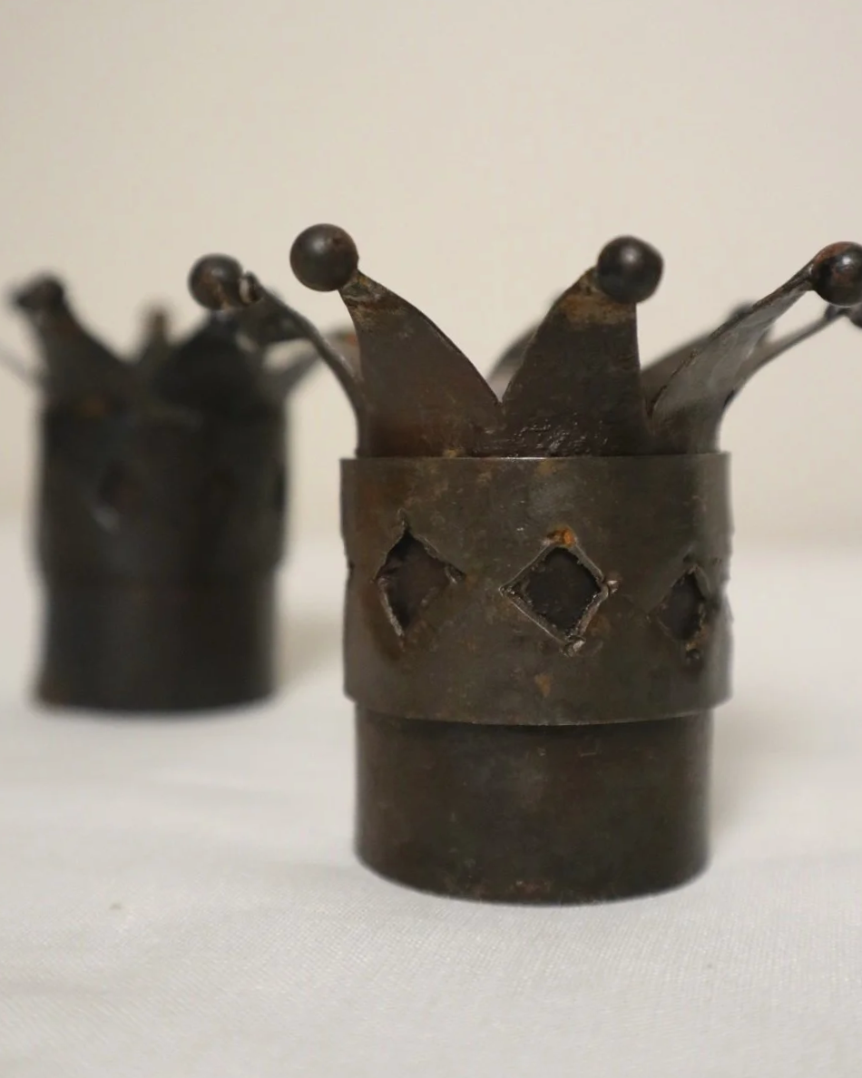 Pair of Modernist style, small dark metal jester hat or crown shaped tea light holders with diamond cut outs.
