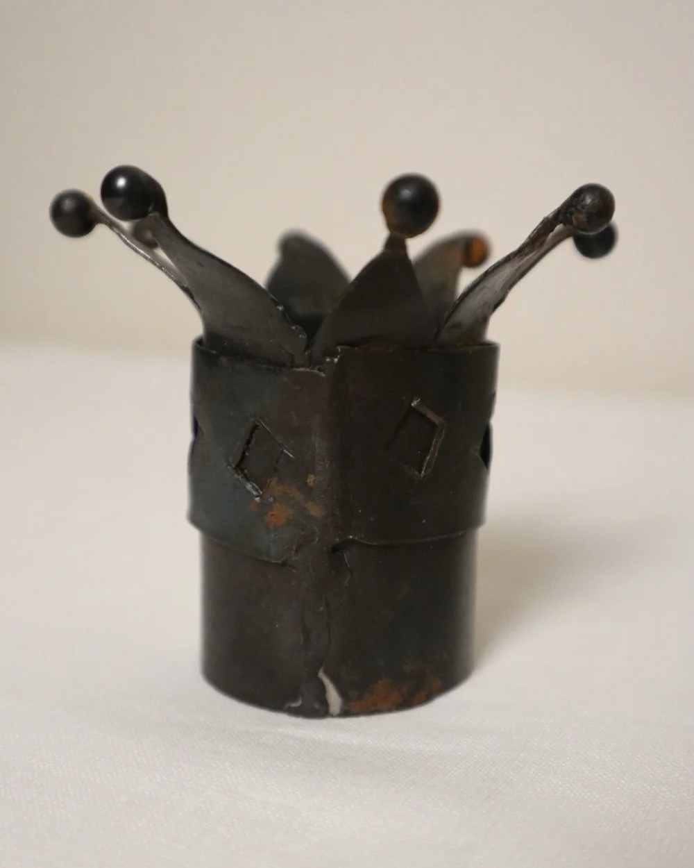 Pair of Modernist style, small dark metal jester hat or crown shaped tea light holders with diamond cut outs.