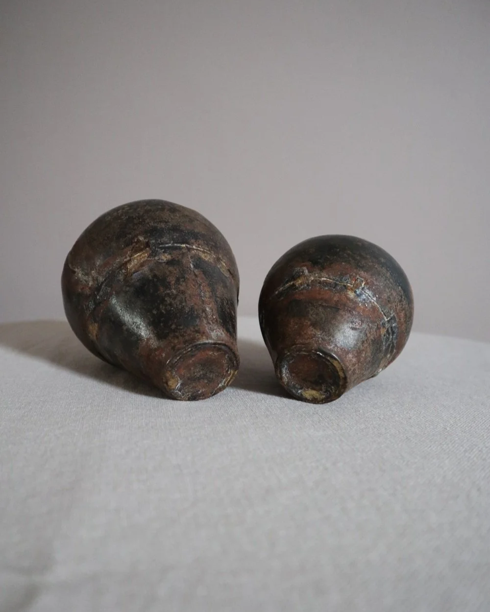 Set of two small, lightweight handmade metal vases of varying sizes.