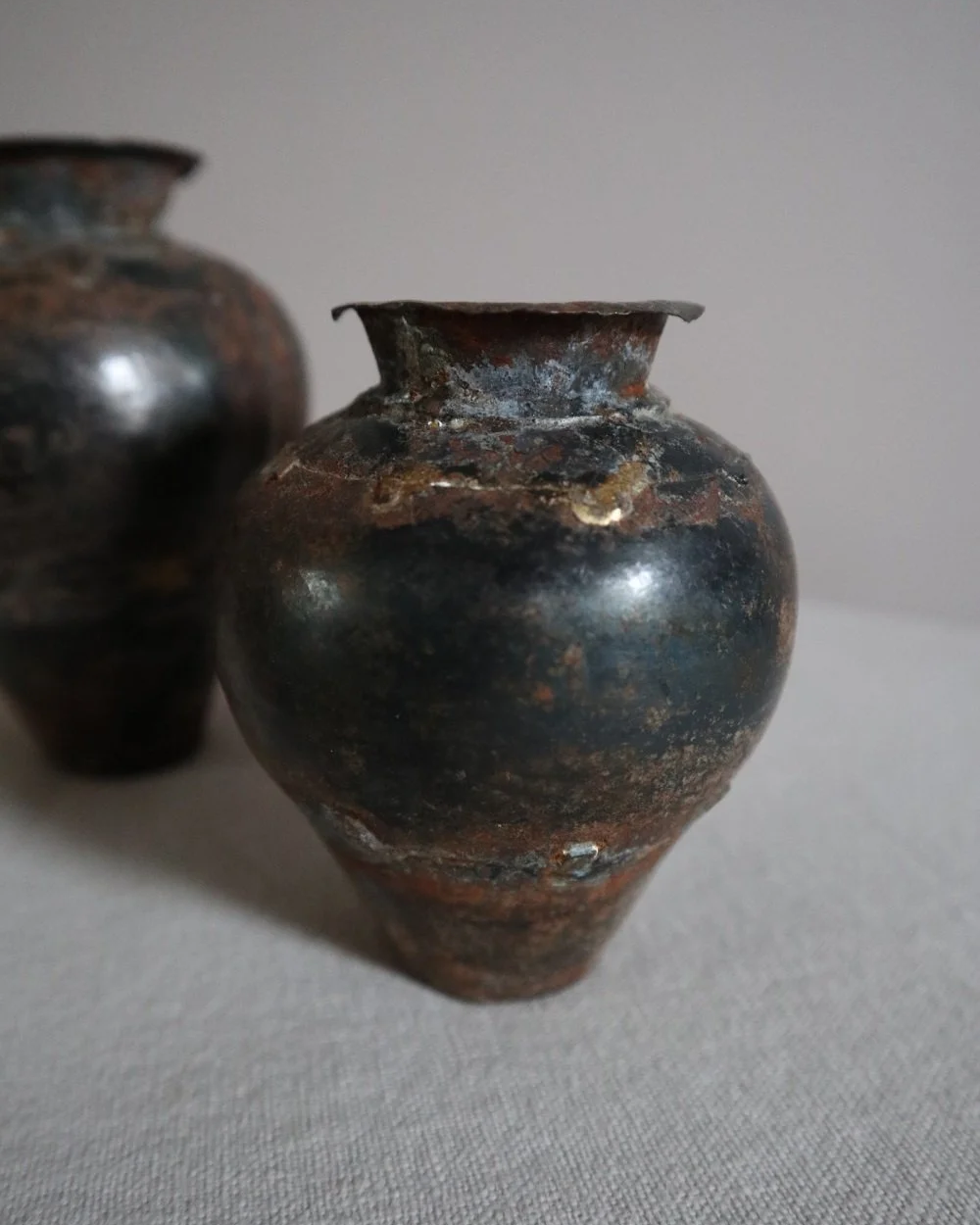 Set of two small, lightweight handmade metal vases of varying sizes.