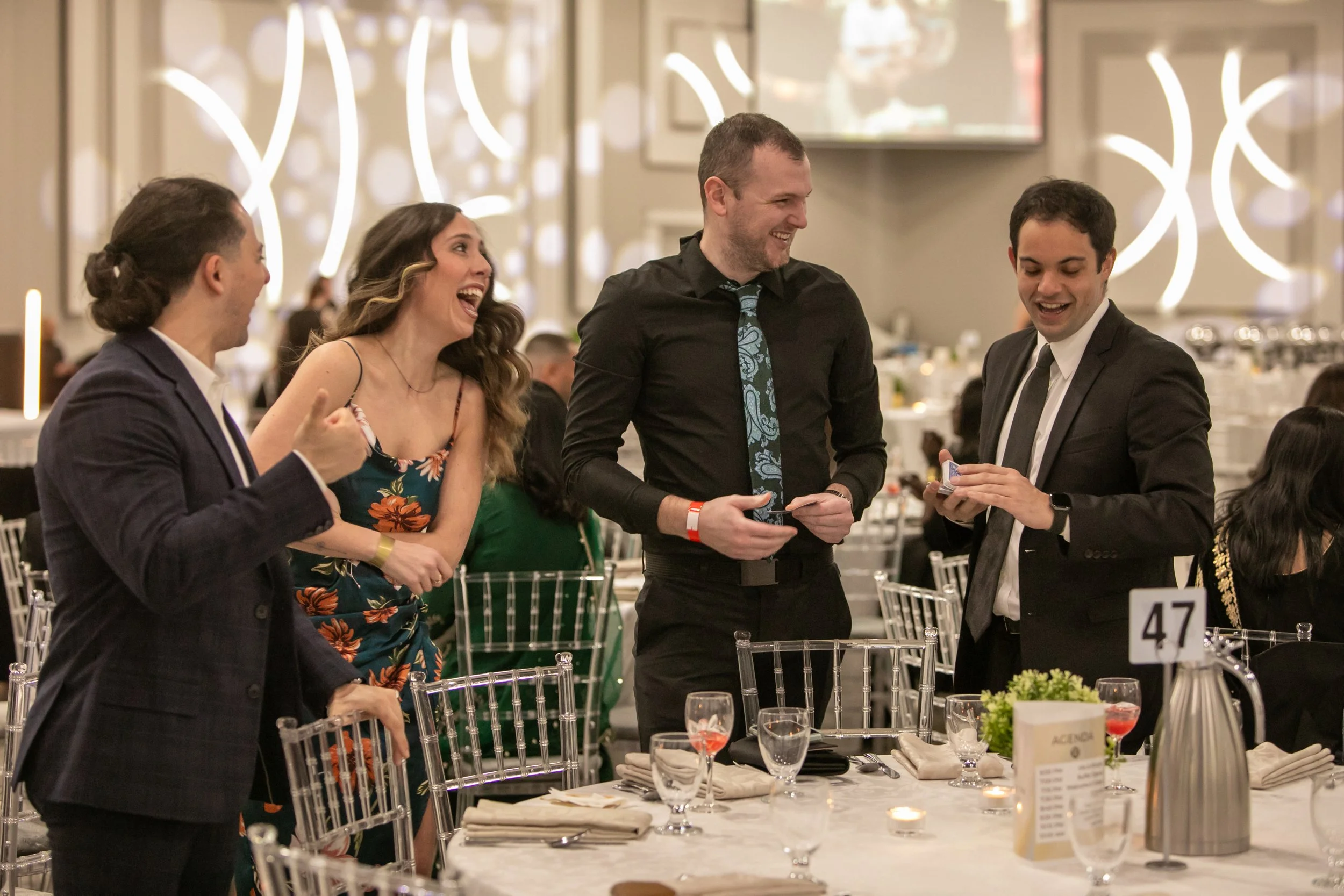 Strolling magician performing close-up magic for guests at a company event