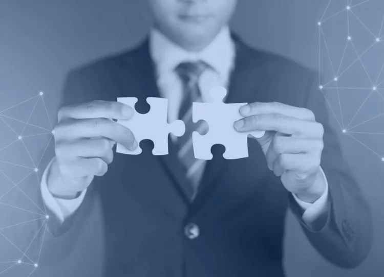 Businessman joining two puzzle pieces