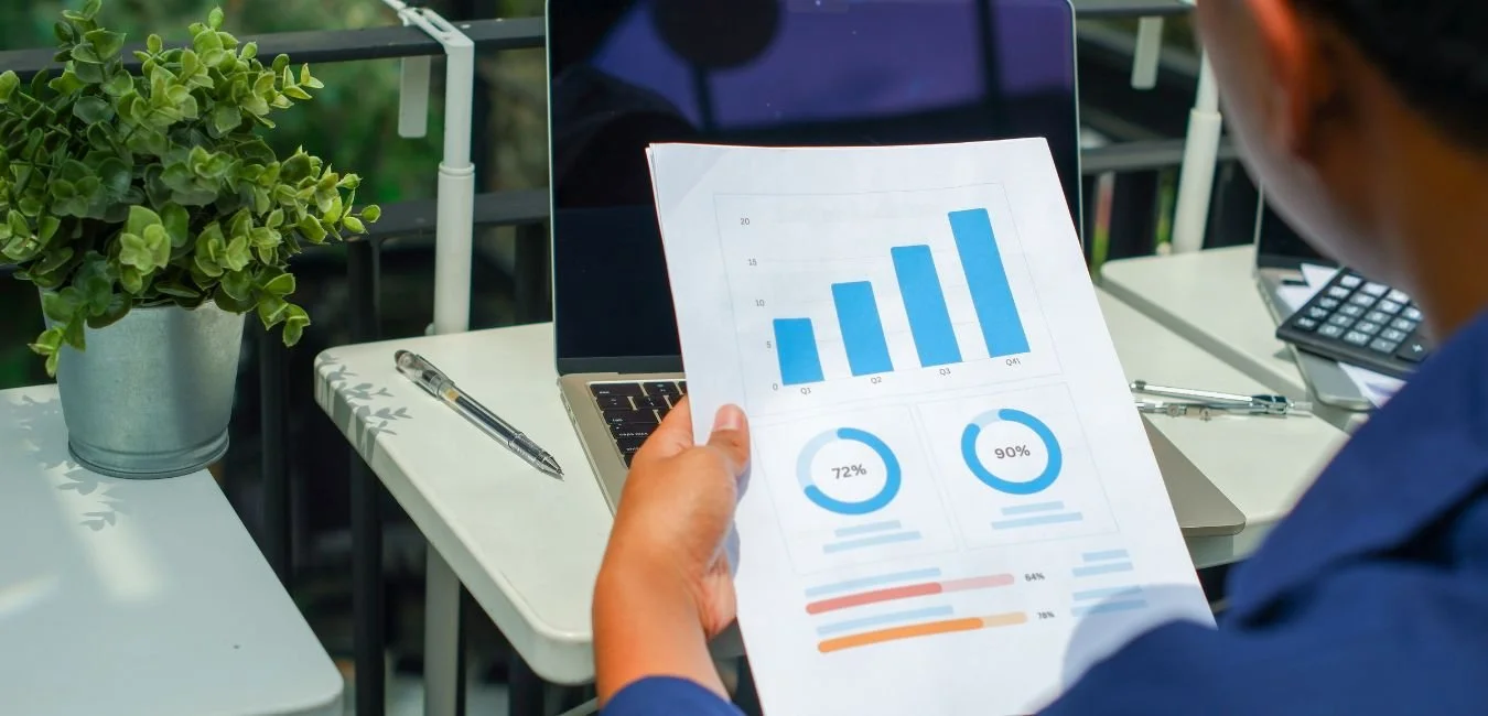 Finance professional reviewing printed financial modelling charts and performance metrics for an NFP or social enterprise