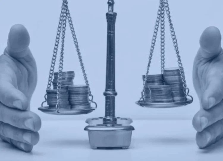 Balance scales weighing stacks of coins