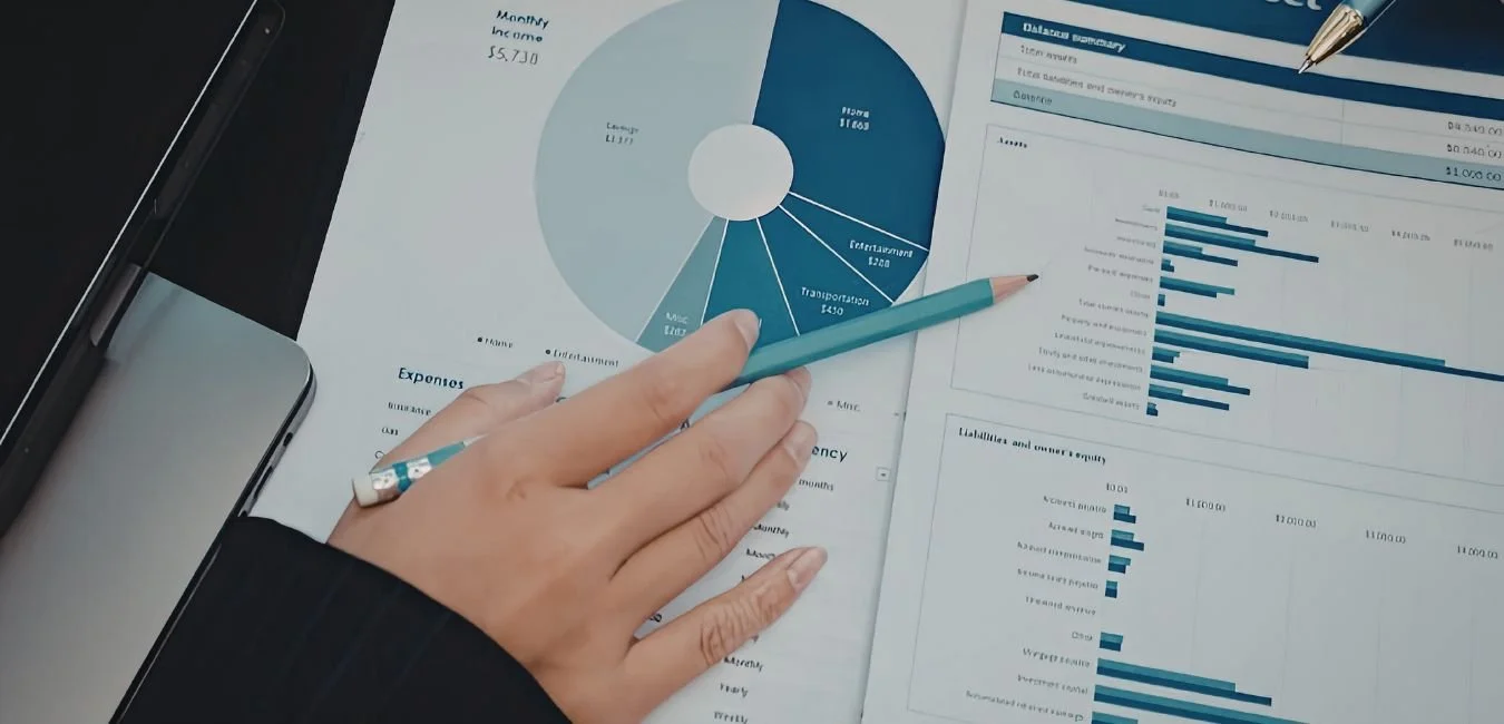 Finance professional reviewing printed financial model reports including balance sheet and expense charts during an audit