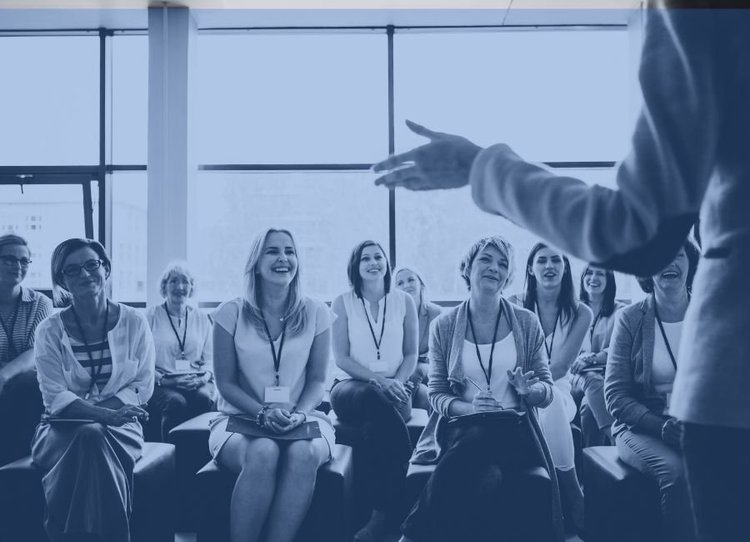 Presenter leading a training session with a seated group