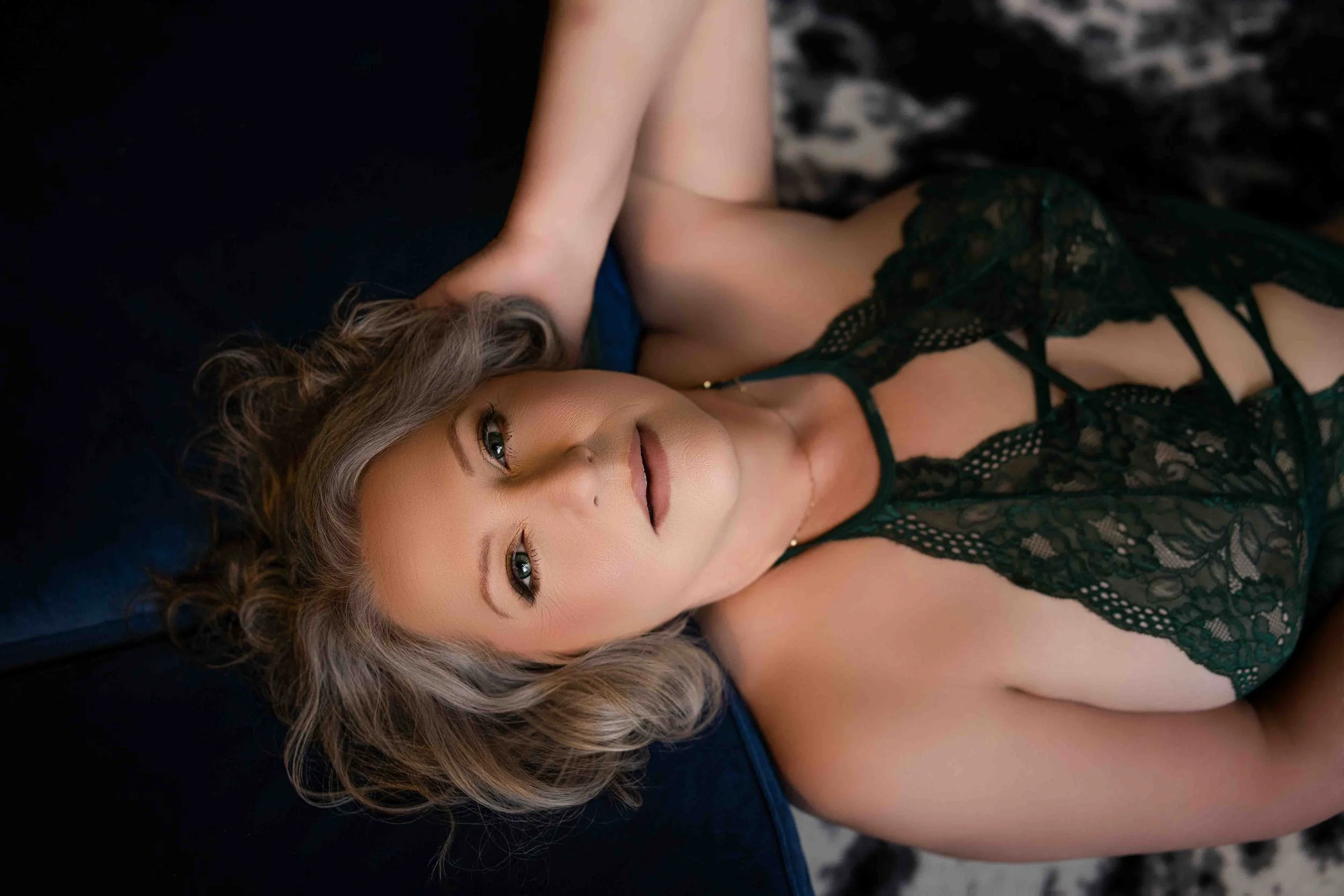 Woman posing in green lace lingerie during a confidence-boosting boudoir makeover experience in Central Arkansas
