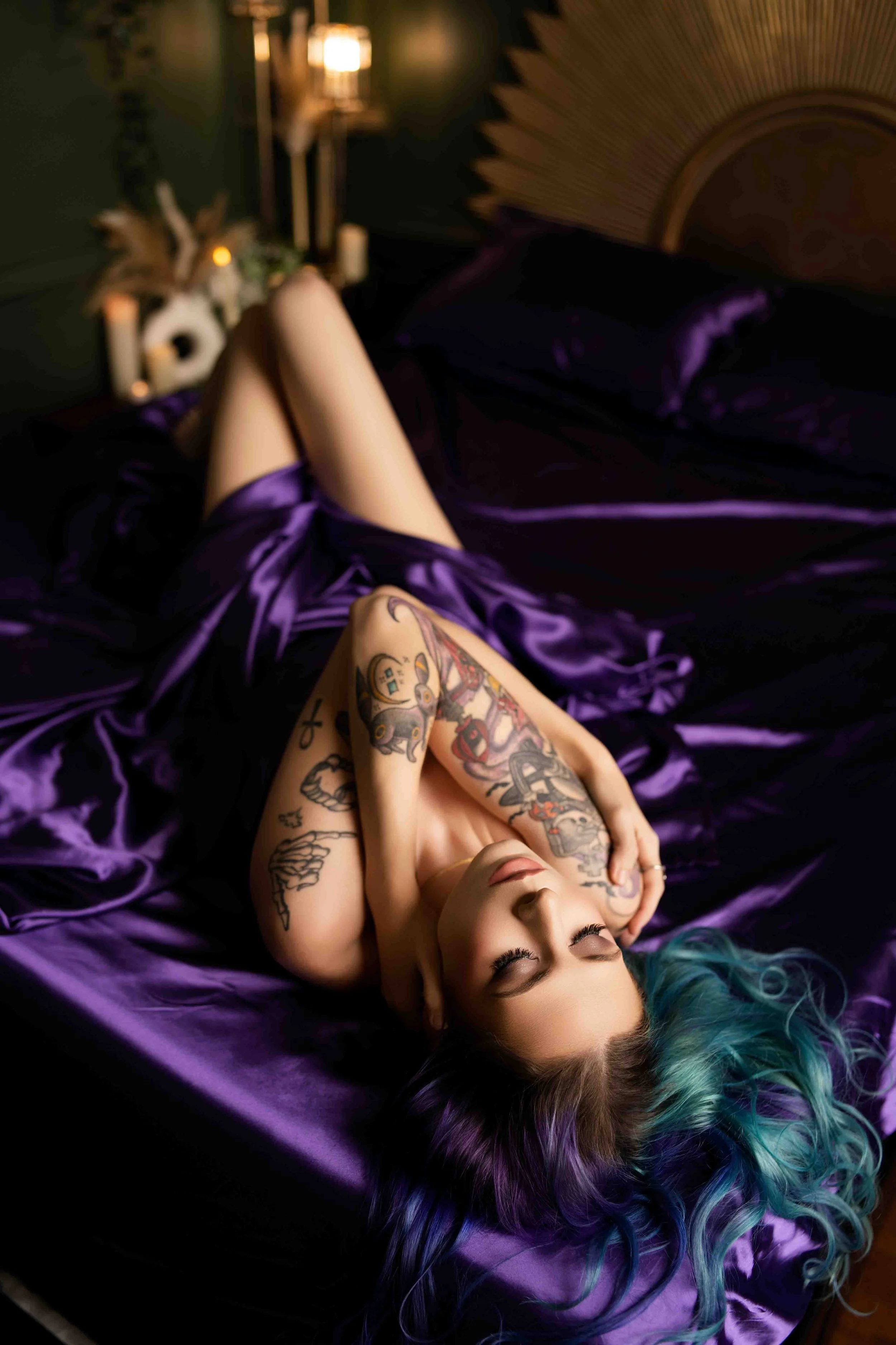 Boudoir session with model on silky purple sheets, showcasing confidence and luxury aesthetic in Cabot, Arkansas.