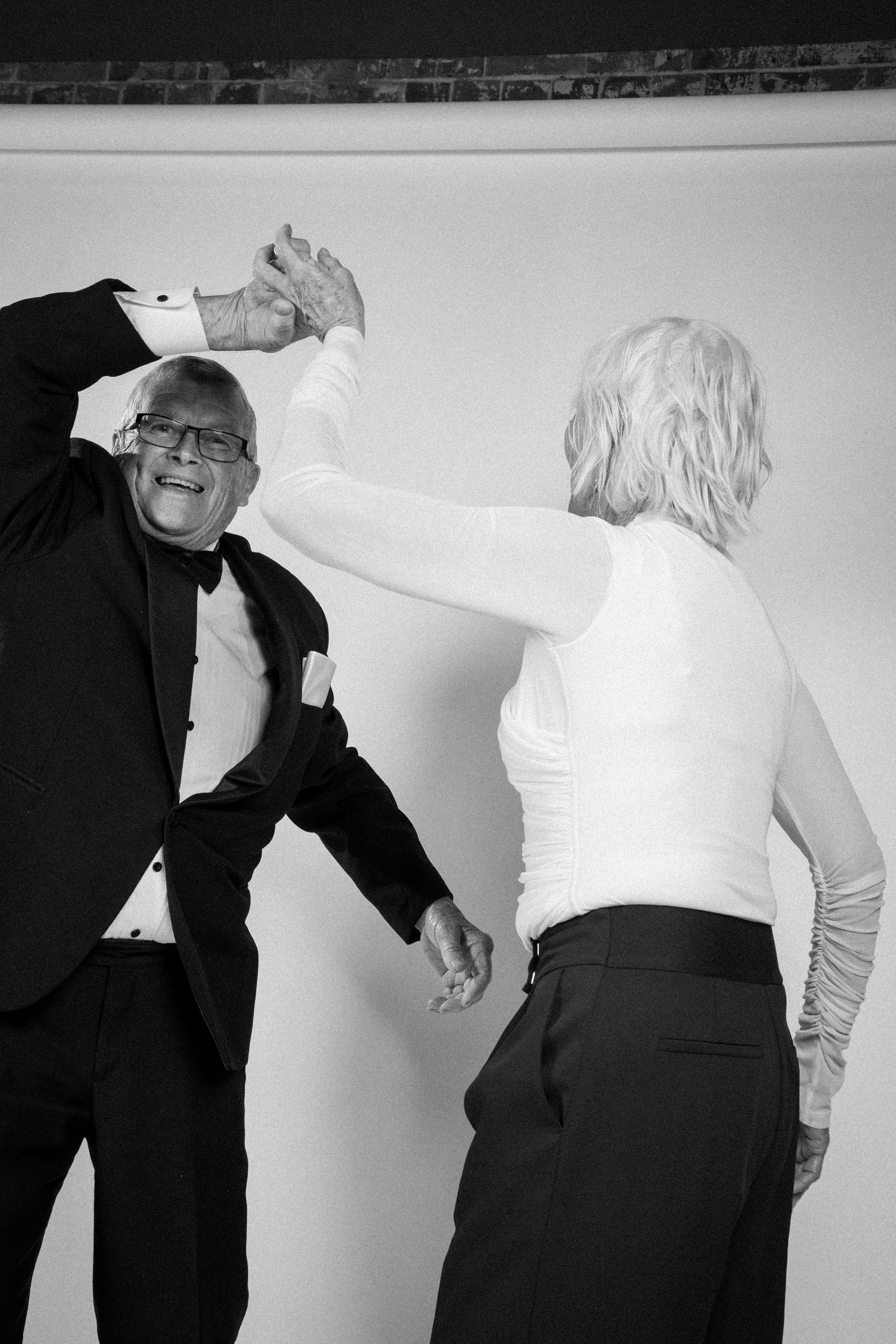 Candid moment of two guests dancing mid-motion in a black-and-white event studio booth