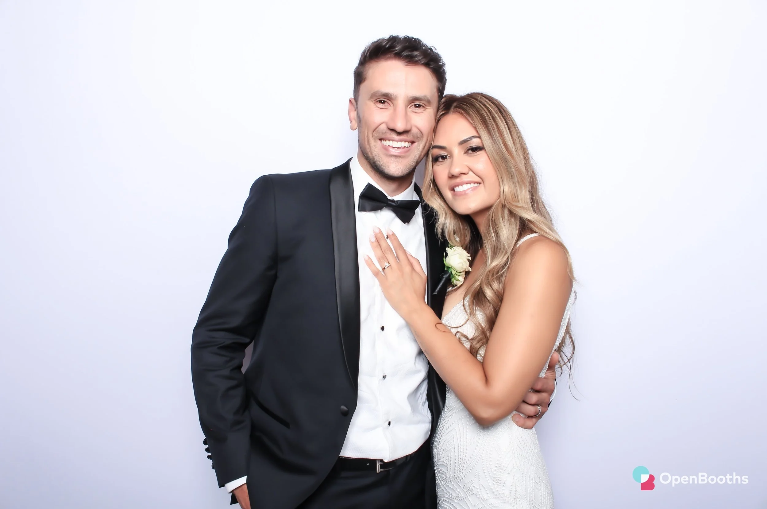 Colour glam filter image of a couple in front of an Open Booths white backdrop