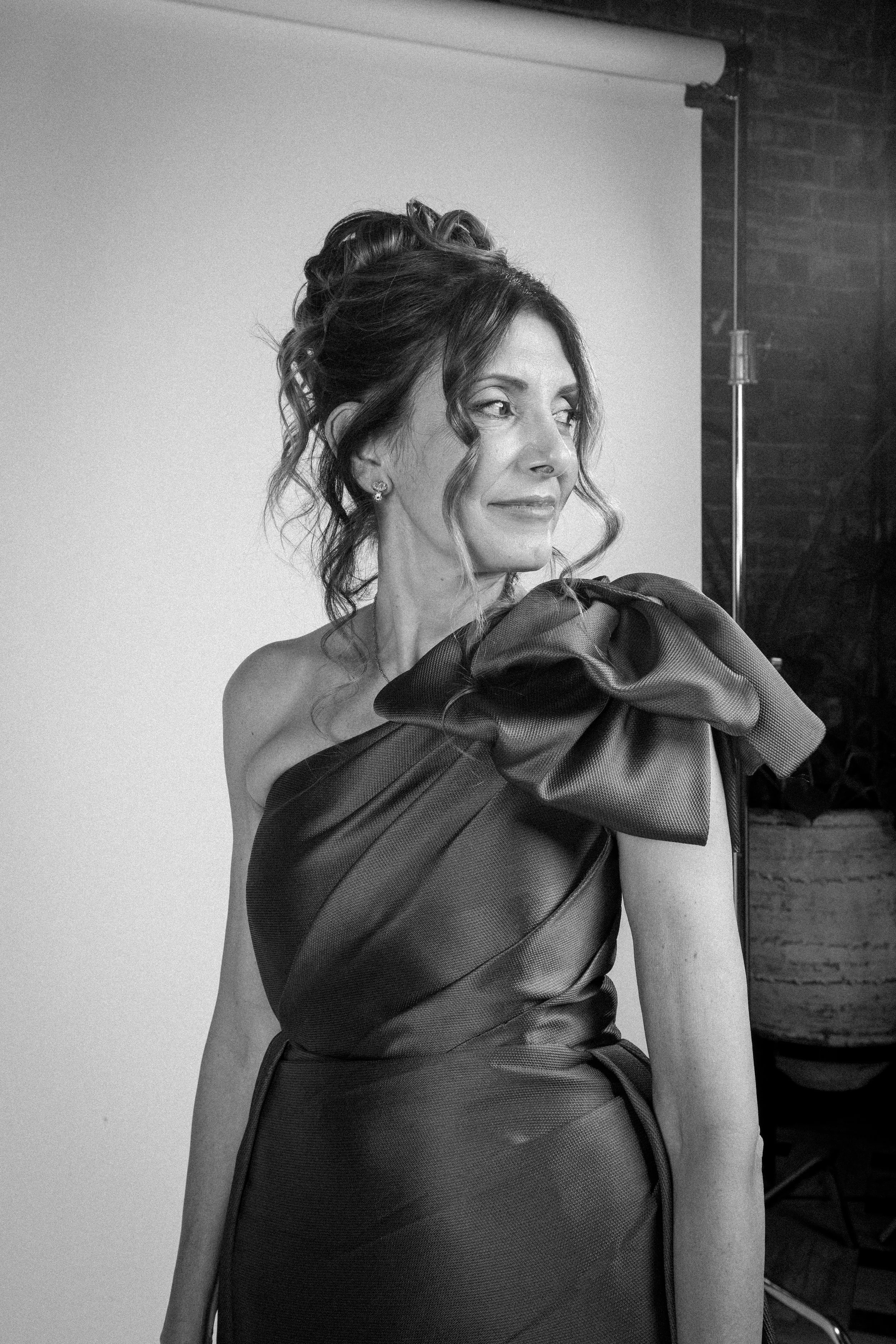Elegant woman looking off camera in a soft-lit, black-and-white wedding portrait.