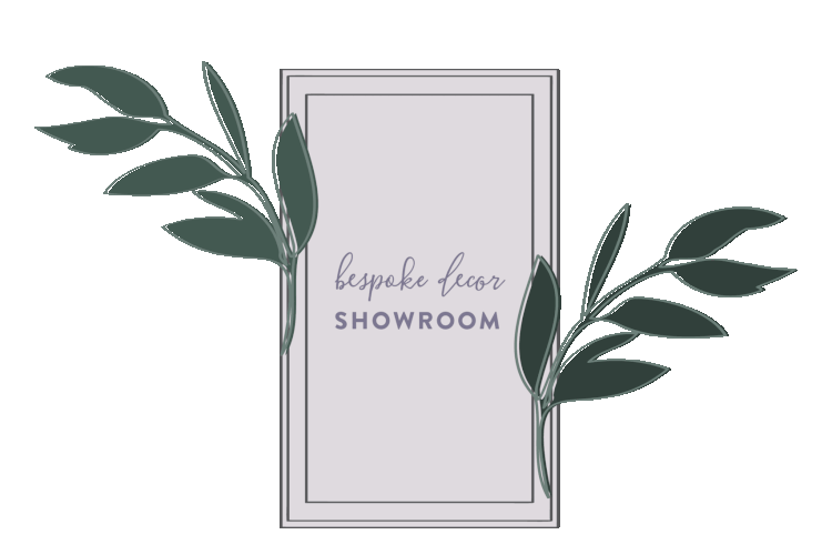 A digital graphic with a white rectangular sign displaying the words "bespoke decor SHOWROOM" and decorated with green leaves on a gray background.