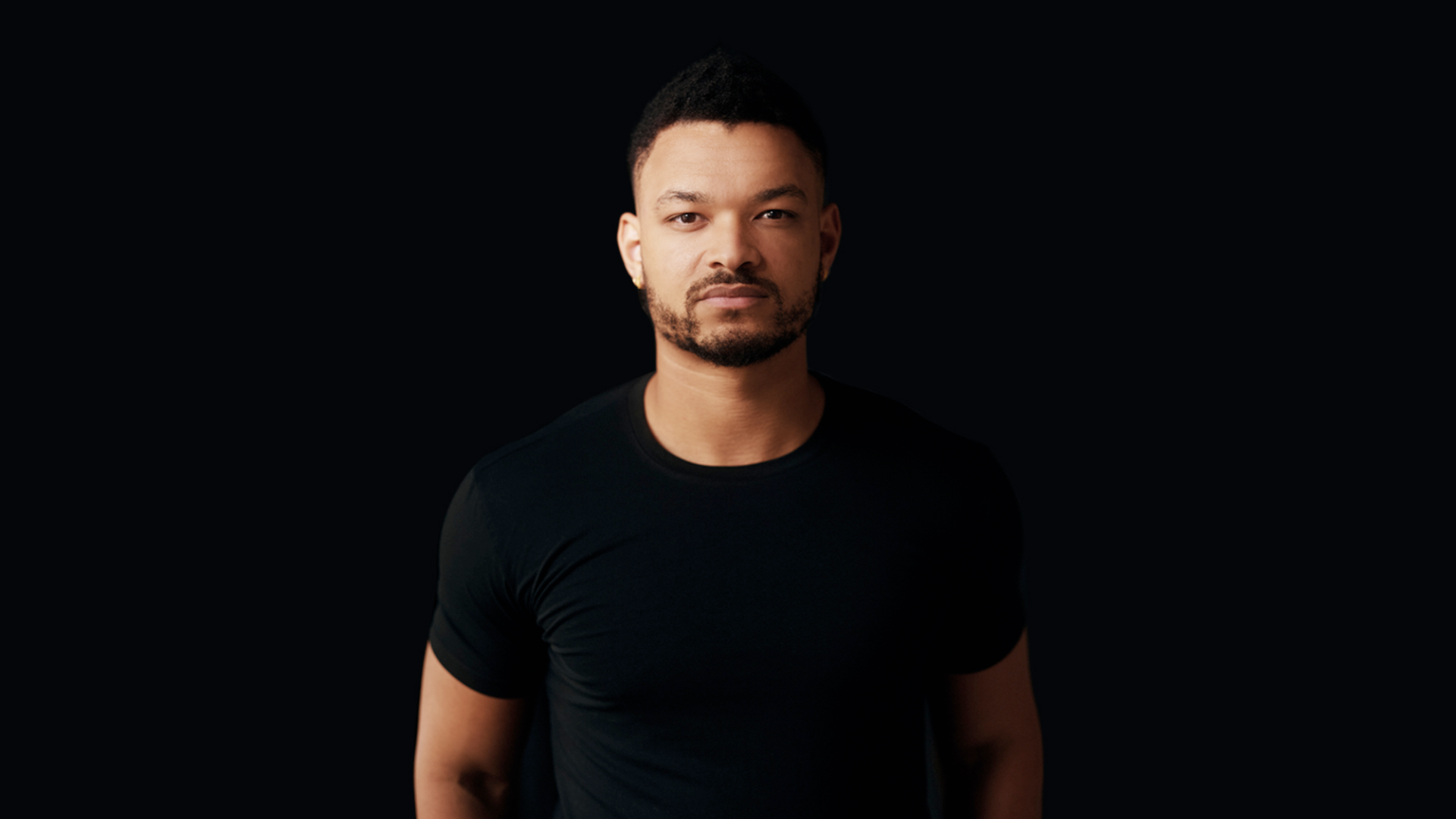 Man in a black shirt against a dark background