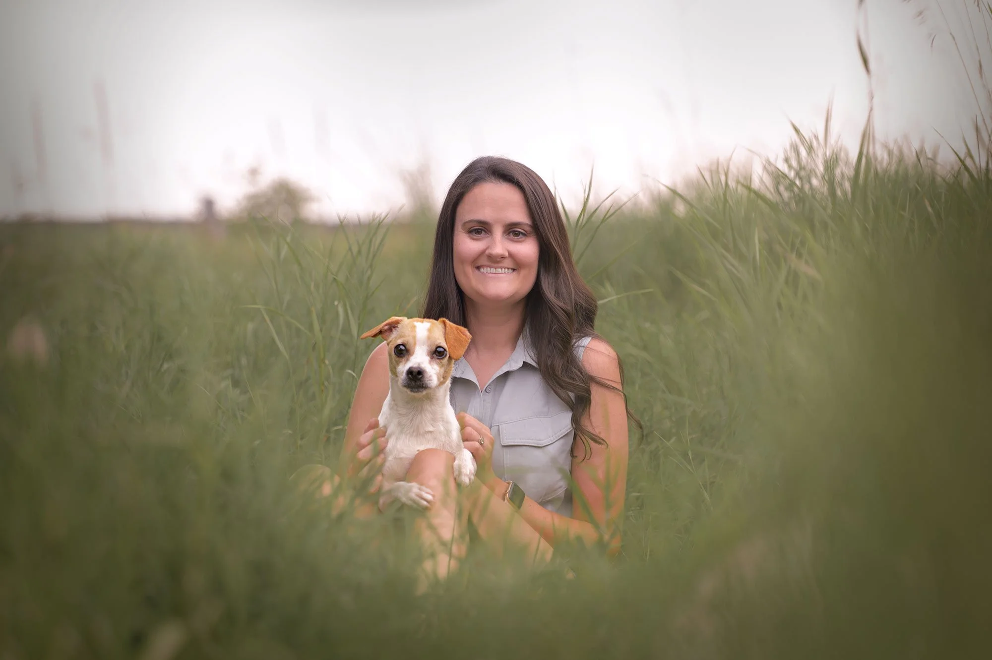 Dog Photography Owner and dog sitting together in field