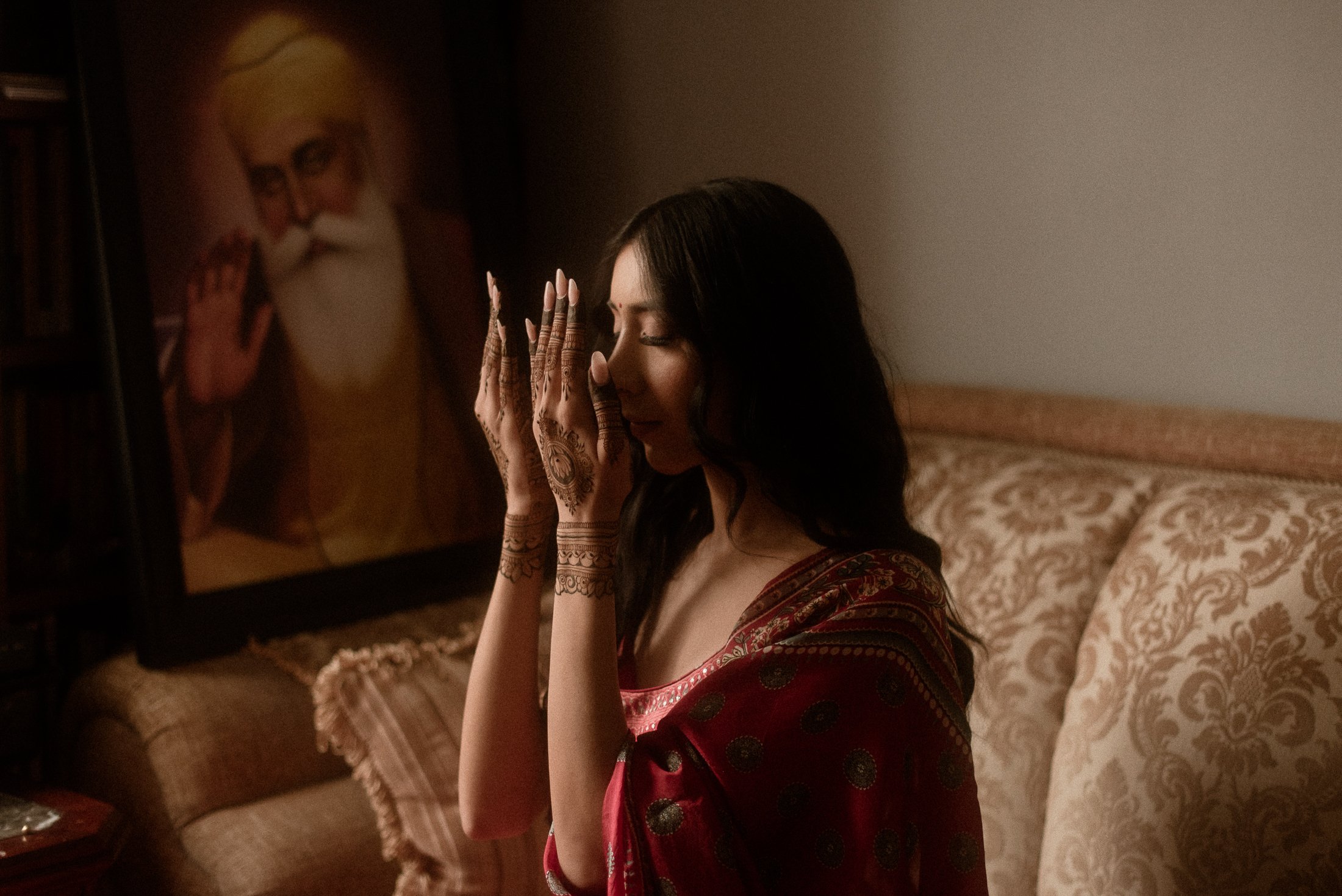 indian bride holding hands with henna close to her face
