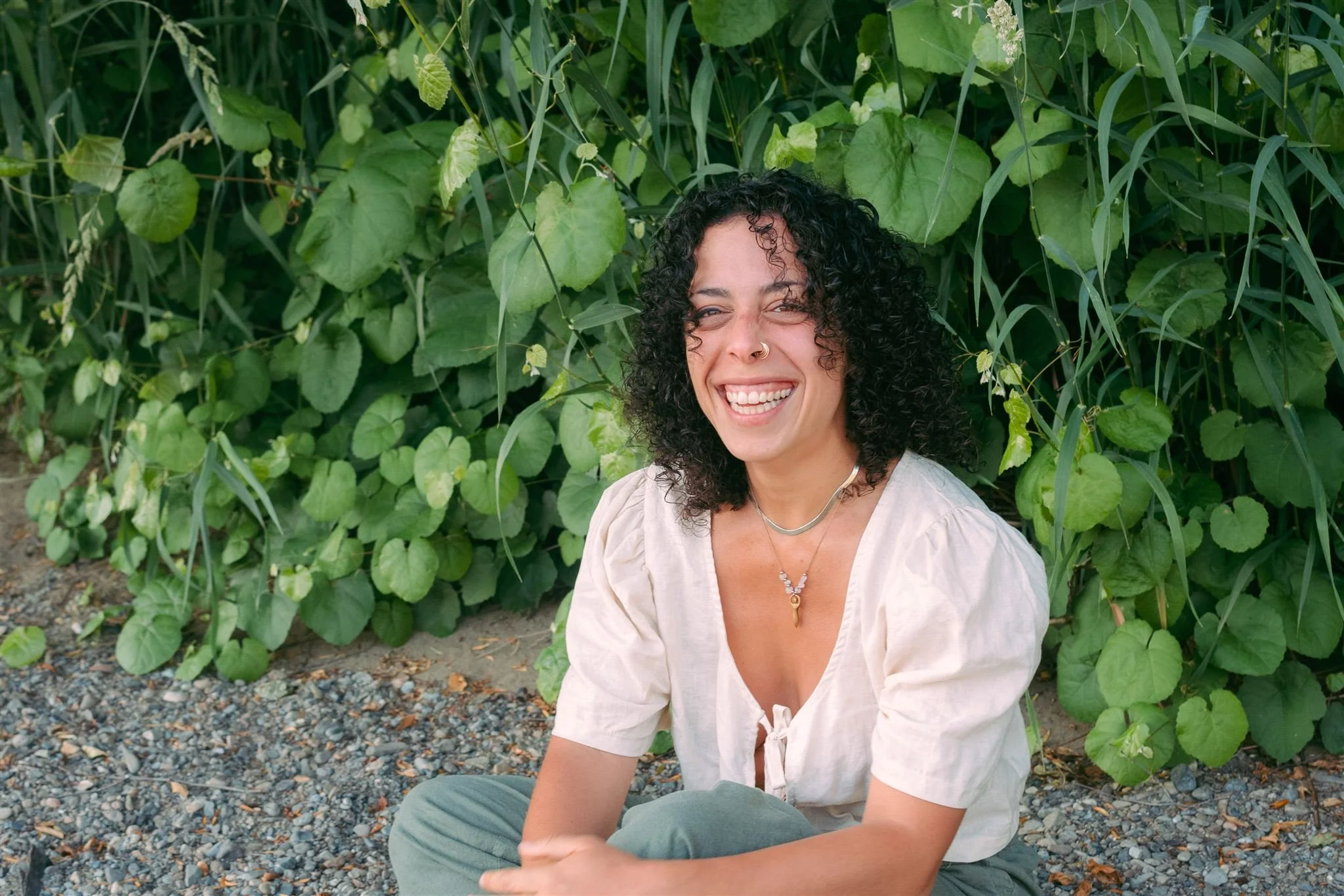 curly haired photographer in toronto smiling and sitting down