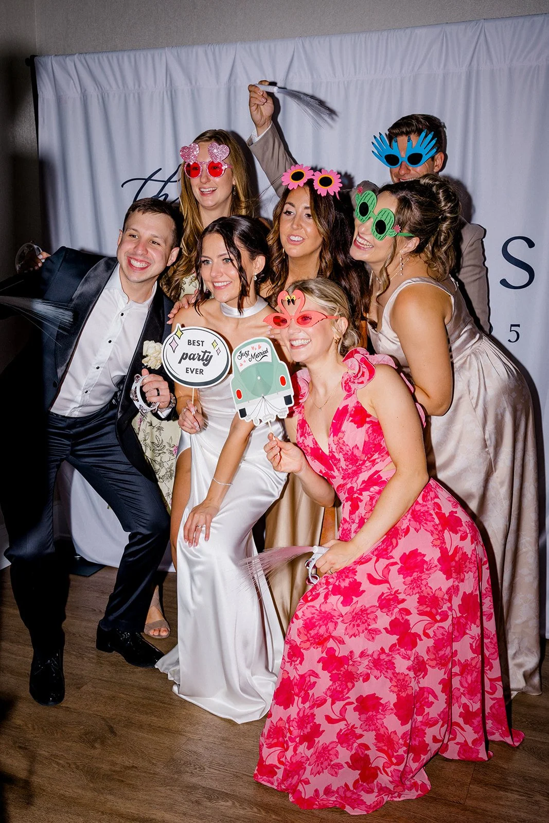 the bride & groom with guests have fun in the photo booth