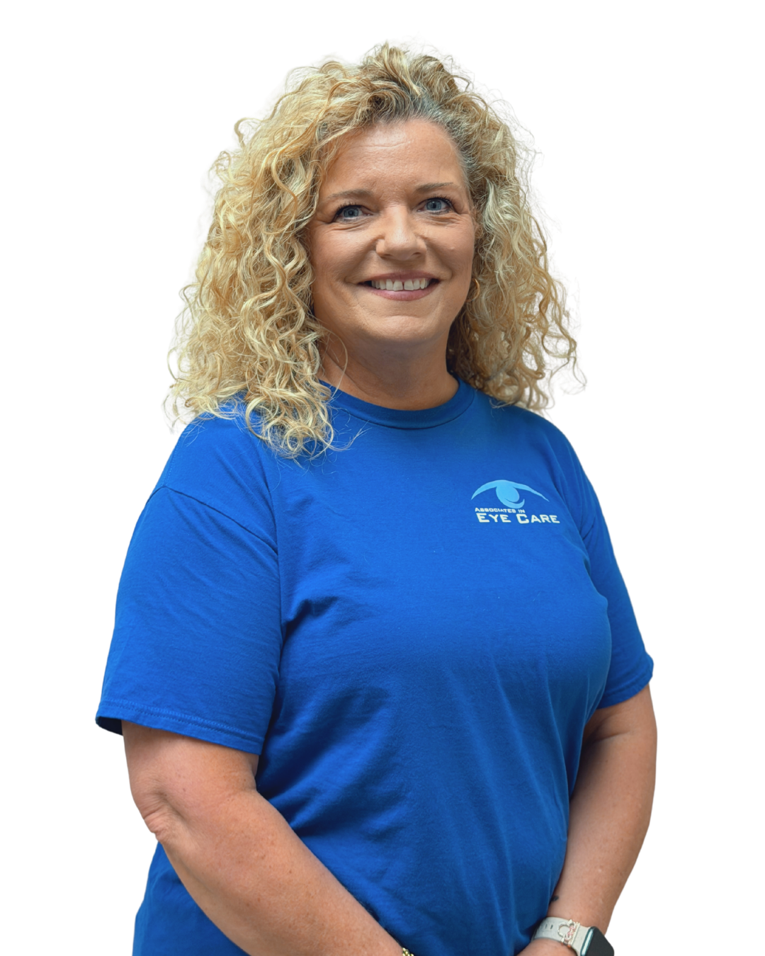 Person in blue medical scrubs smiling, with light curly hair and hoop earrings.