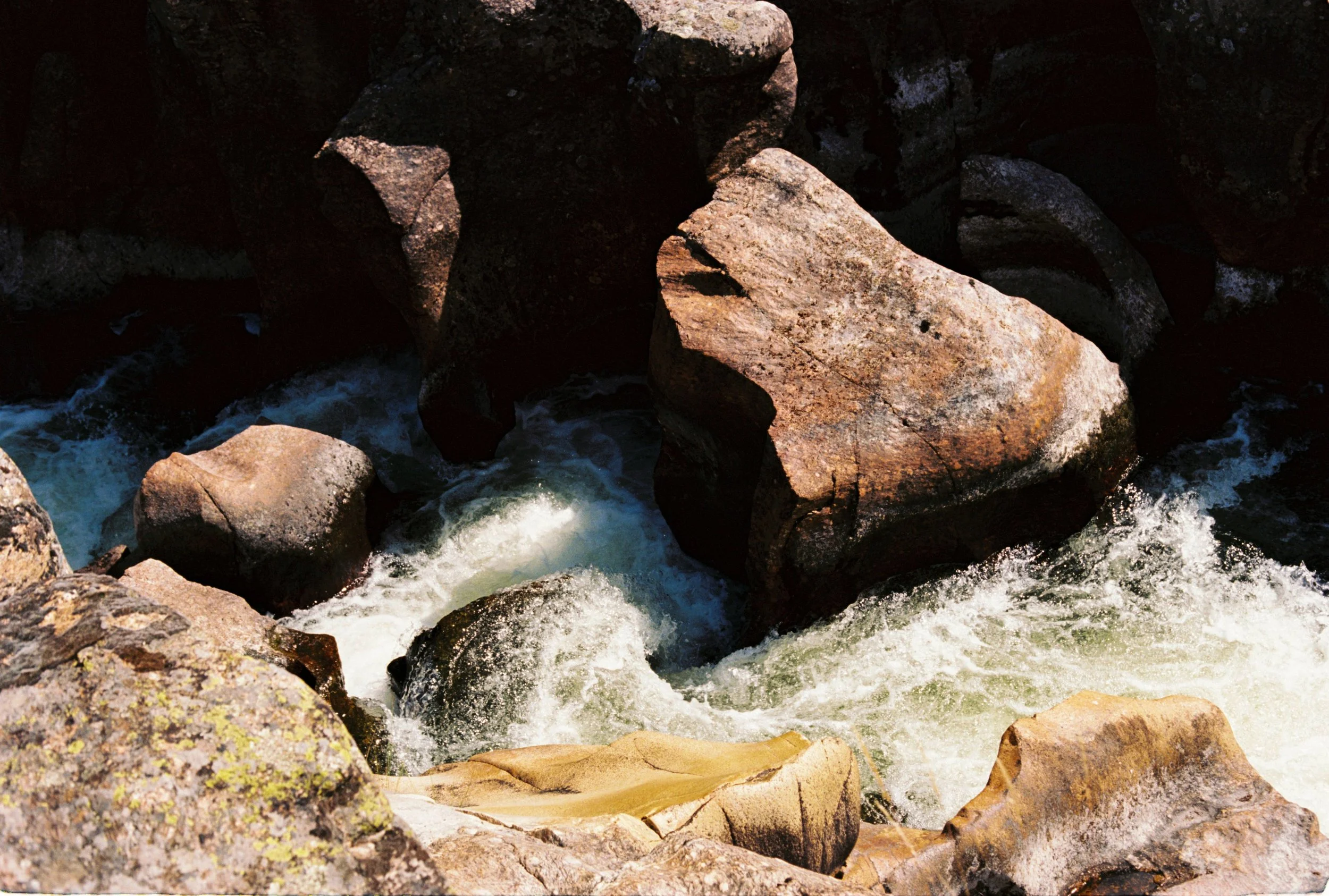 Rushing water flowing through rocks in a river or stream.