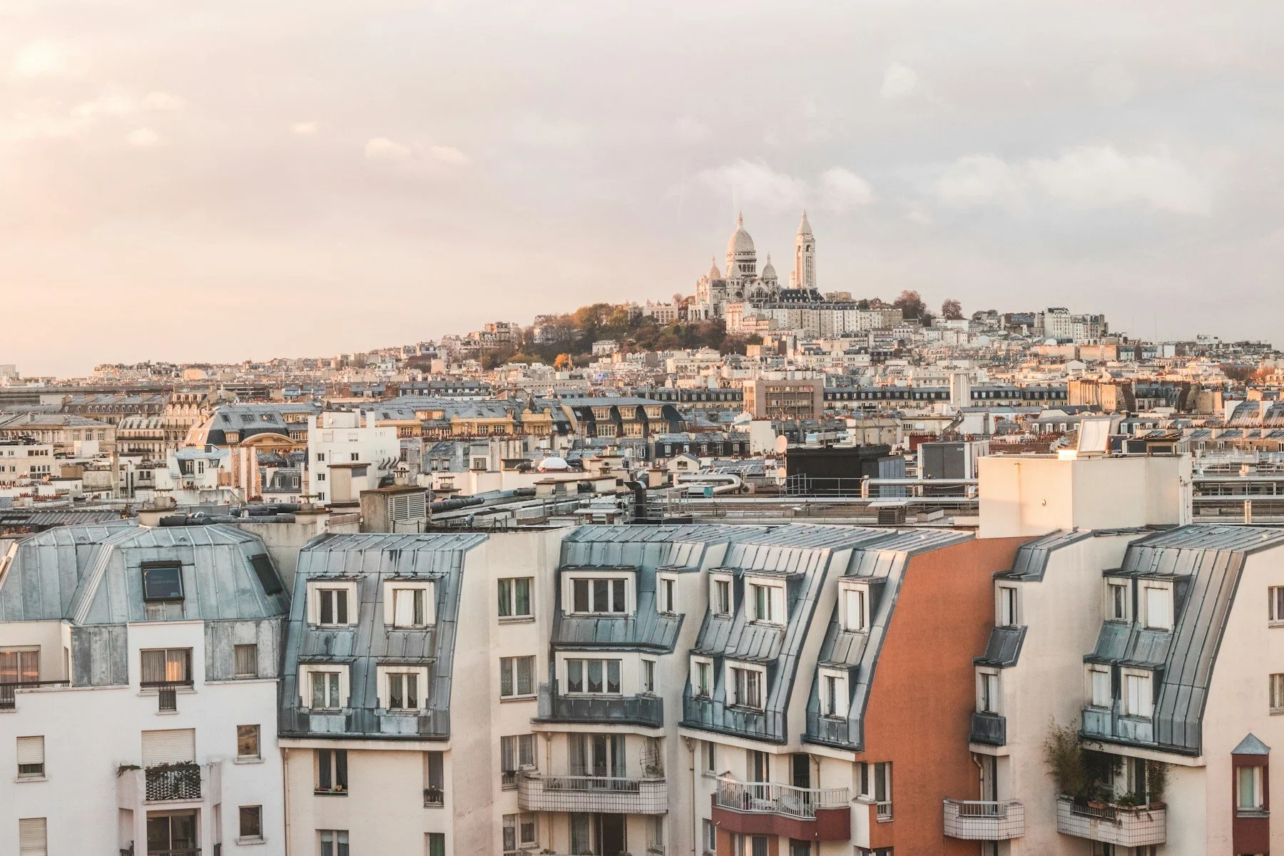 Toits de zinc et immeubles parisiens avec vue sur la butte Montmartre