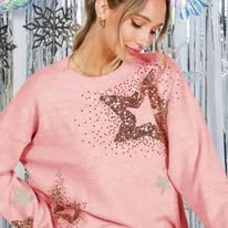 Close-up of a woman wearing a pink sweater with star-shaped embellishments and metallic accents.