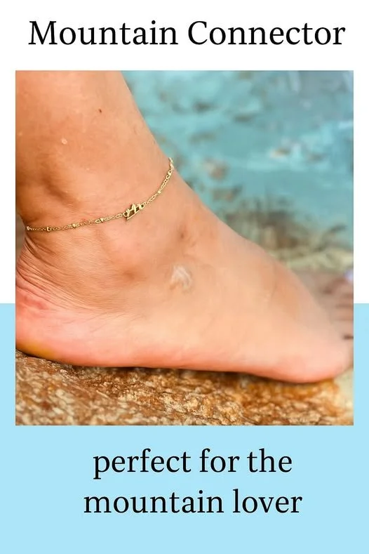 Close-up of a bare foot with an anklet on a rocky surface with a blurred water background. Text at the top says 'Mountain Connector' and at the bottom says 'perfect for the mountain lover'.