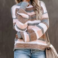 Person wearing a multicolored striped sweater and blue jeans, holding a small purse.
