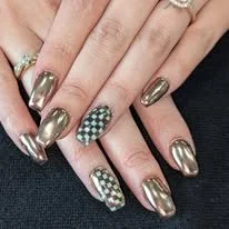 Close-up of hands with metallic gold and green checkered nails.