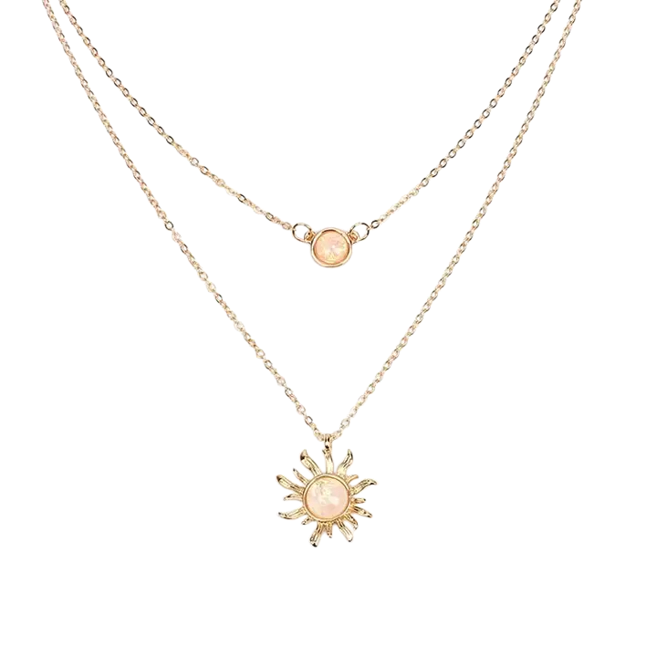 Two layered gold necklaces with pink circular pendants, one sun-shaped and the other simple.