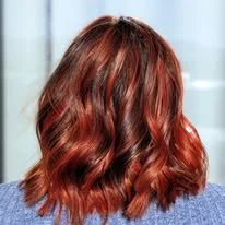 Back view of a woman with shoulder-length red wavy hair