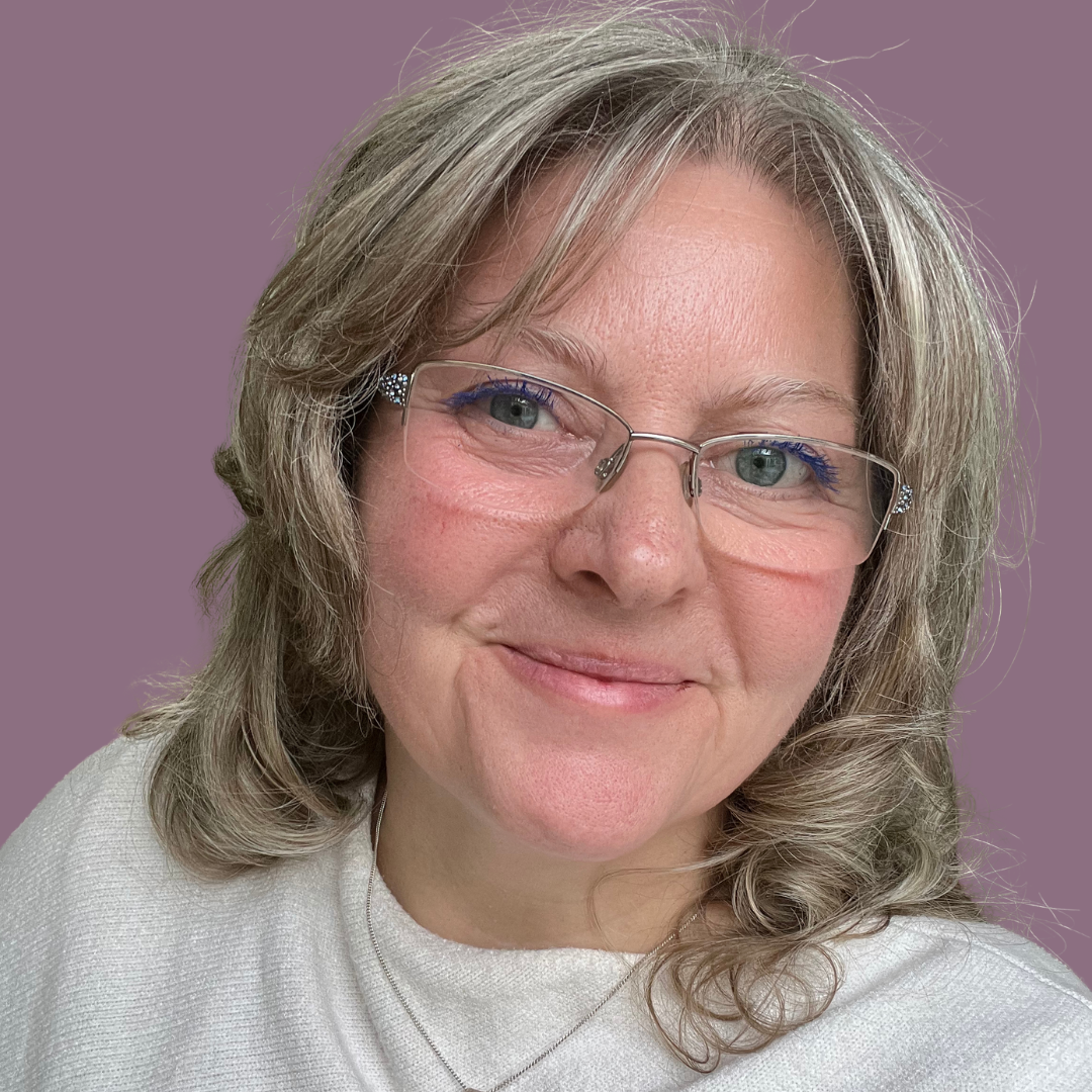 Clare Cusack smiling gently, wearing glasses, and a white top, with a purple background.