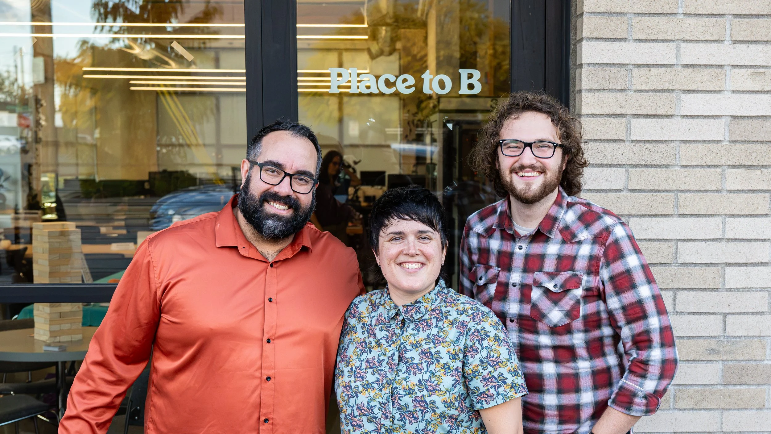 Three team members smile for a photo