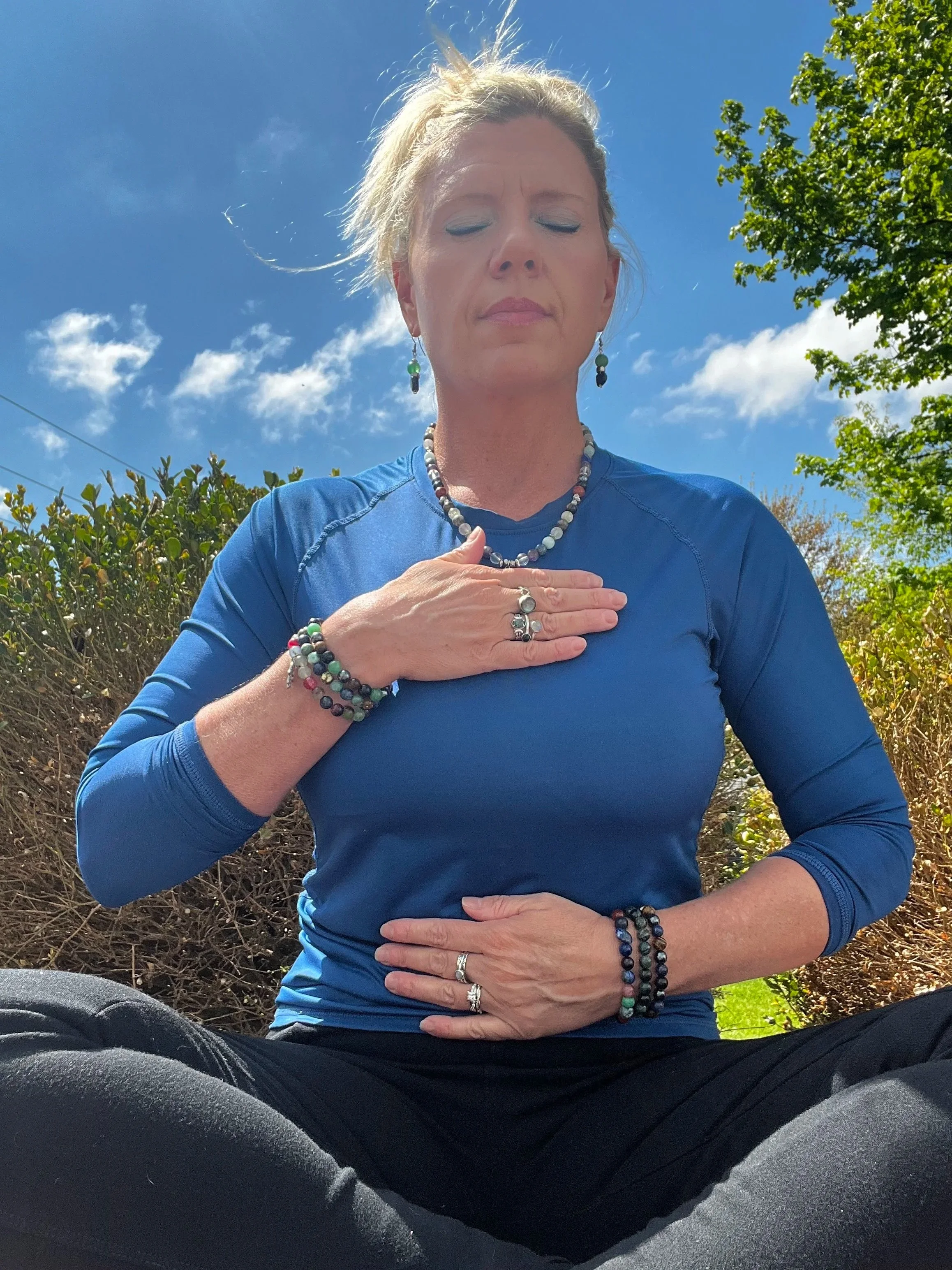 Reiki Master Teacher, Melissa Eaton, performing self-reiki for grounding practices.