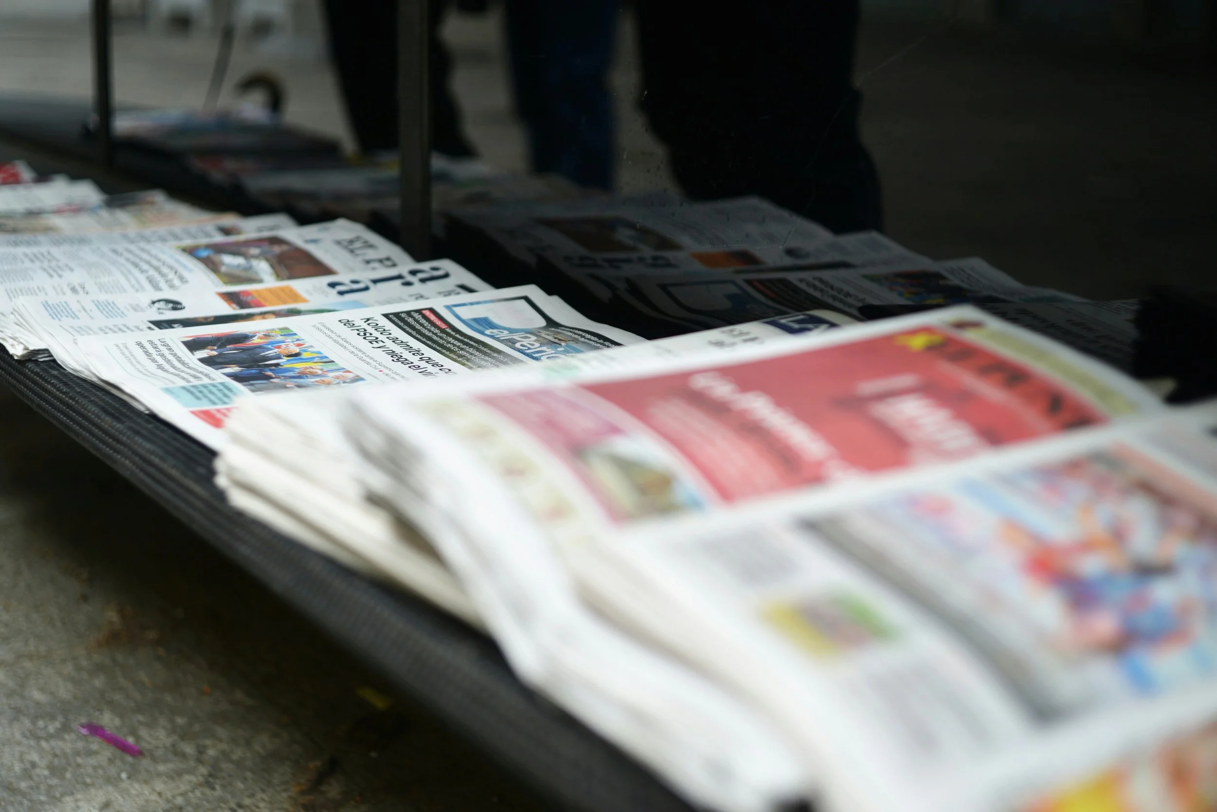 Newspapers displayed on a street vendor's rack