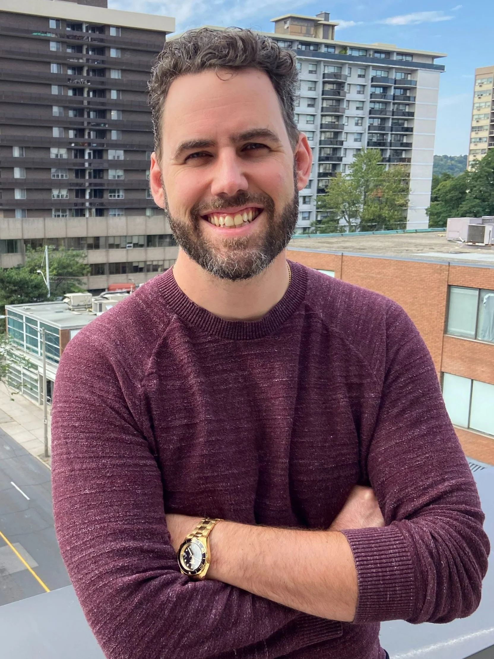 Scott Page standing outside, smiling, wearing a red sweater