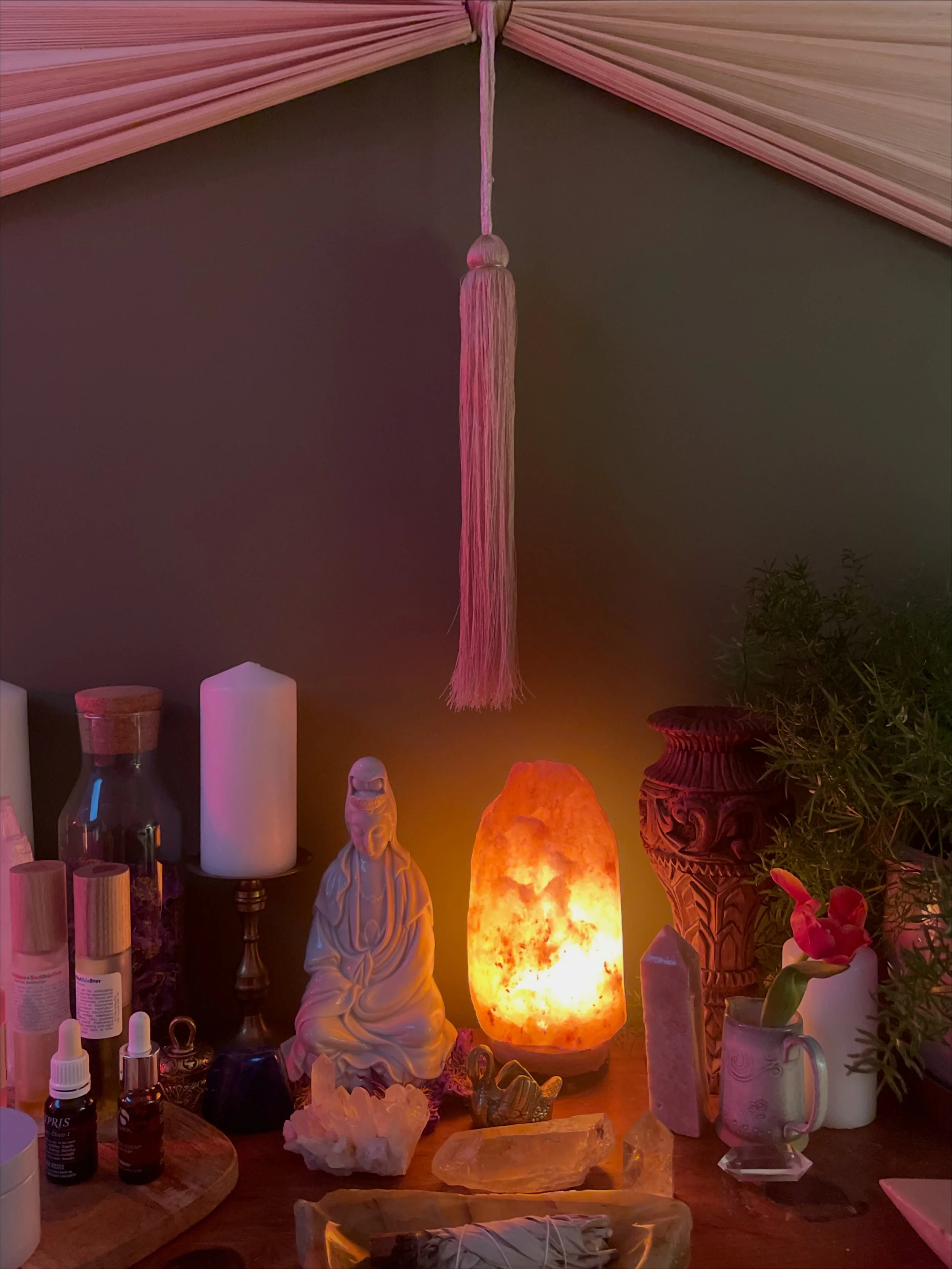 Reiki treatment with hands hovering over person's body, stones placed on chest.