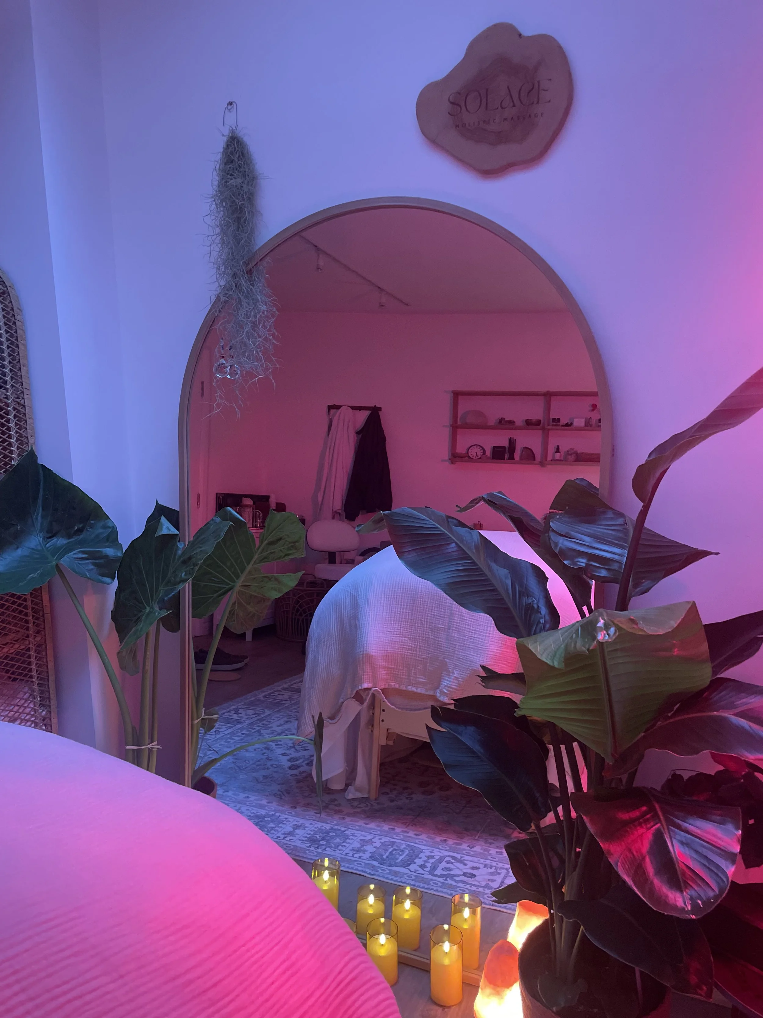 Person receiving a facial massage from a therapist in a spa-like setting.