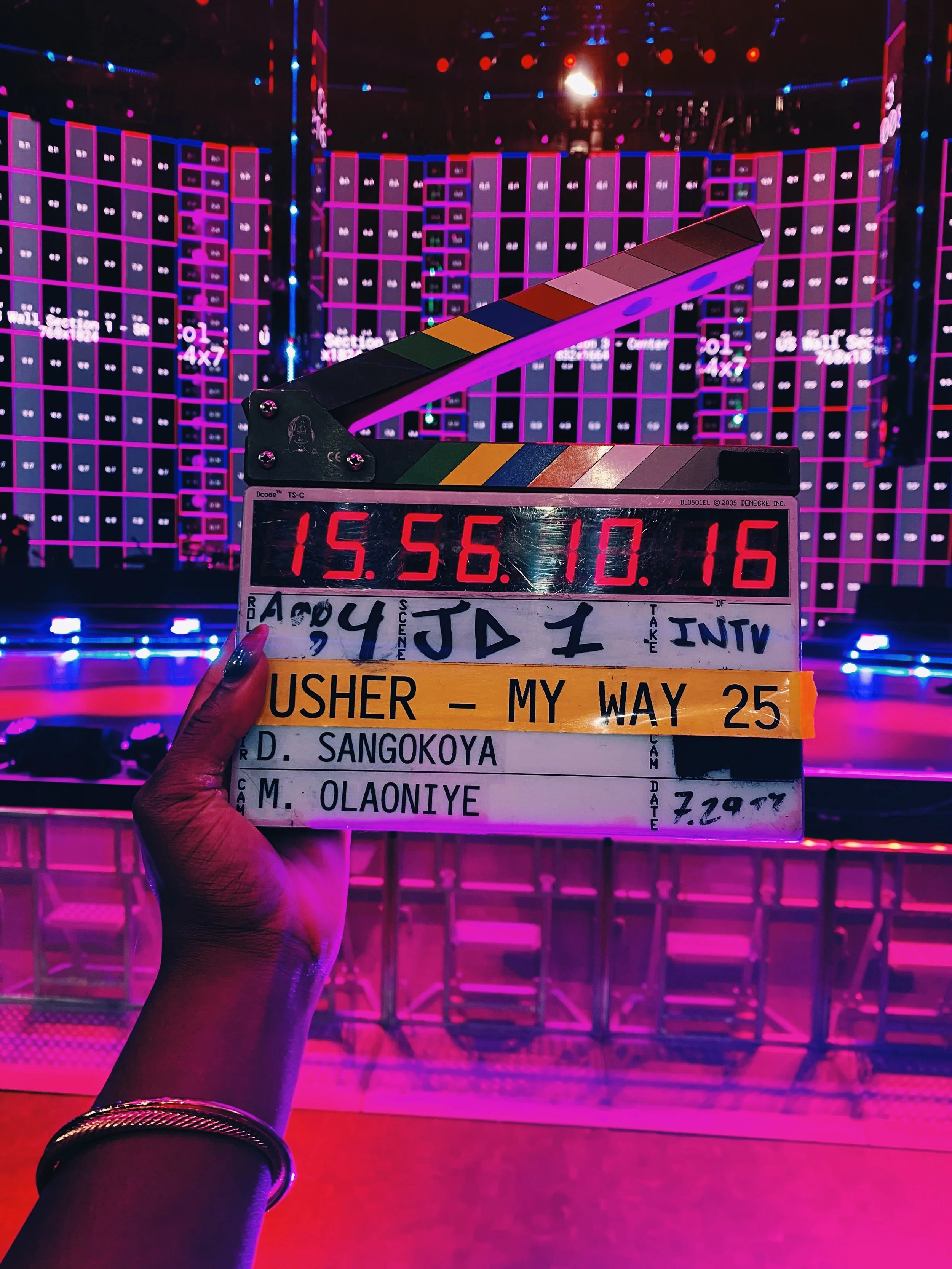 Clapperboard slate  for "Usher - My Way 25 Mini-Doc" directed by Dolapo Sangokoya in front of stage setup.