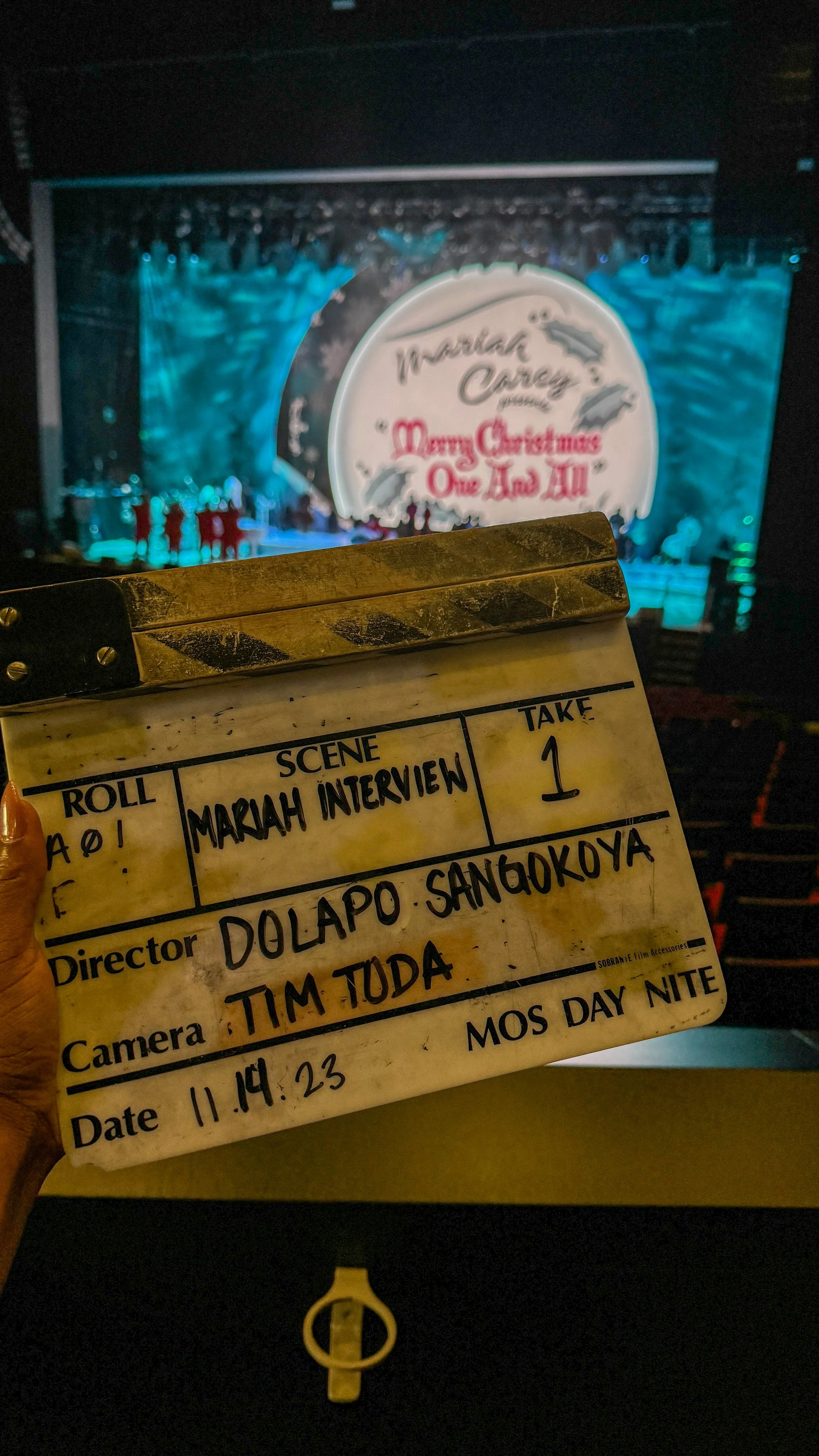 slate for Mariah Carey interview shoot directed by Dolapo Sangokoya in theater with Christmas concert backdrop