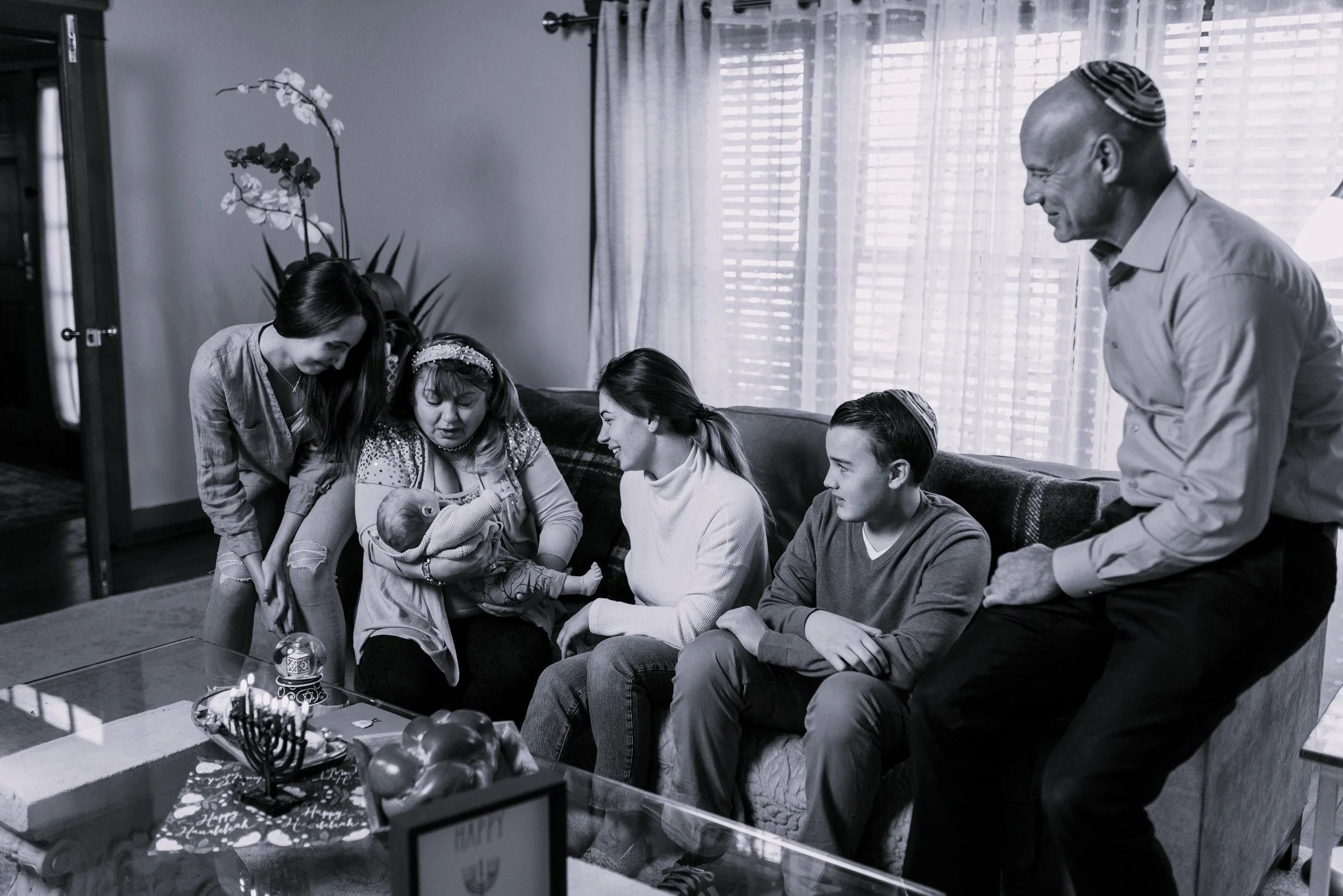 black and white photo of family with interfaith welcoming new babay to family mixed faith family counseling