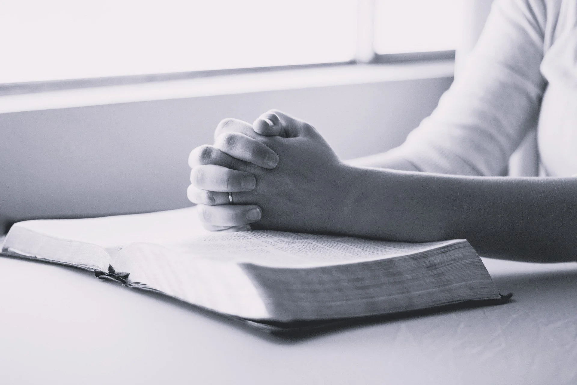 black and whote photo of a person hands on a book