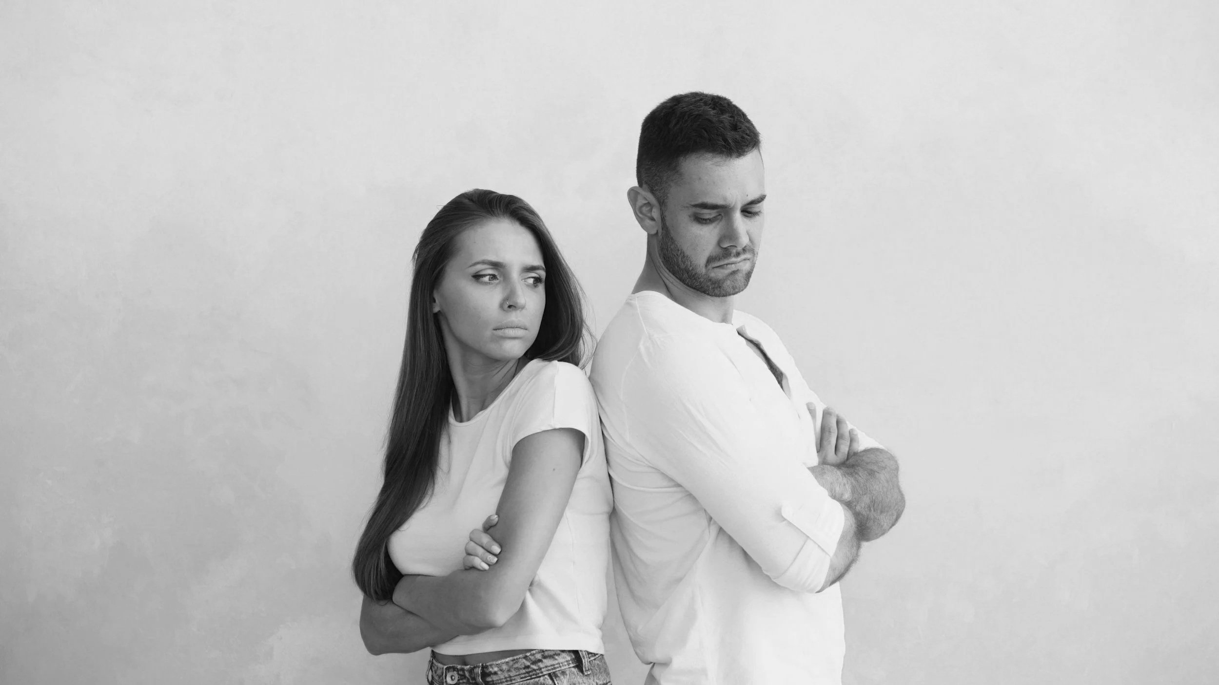 black and white photo of couples back to back upset