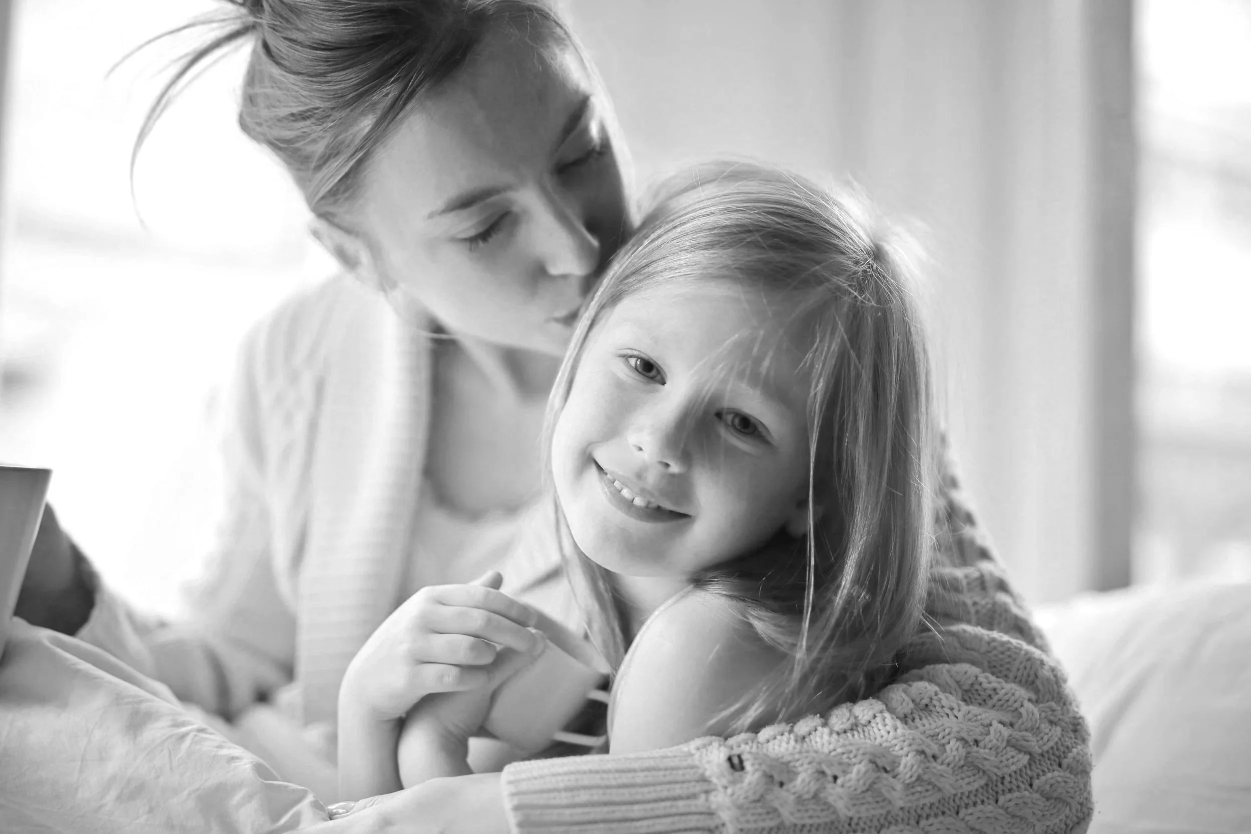 divorced mother and young daughter hugging
