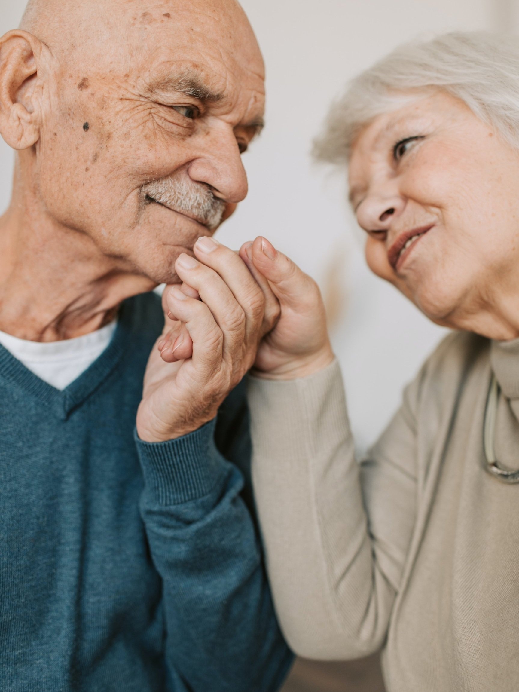 Close up shot of an elderly couple holding hands and looking each other in the eyes. They are in couples counseling in Riverside CA