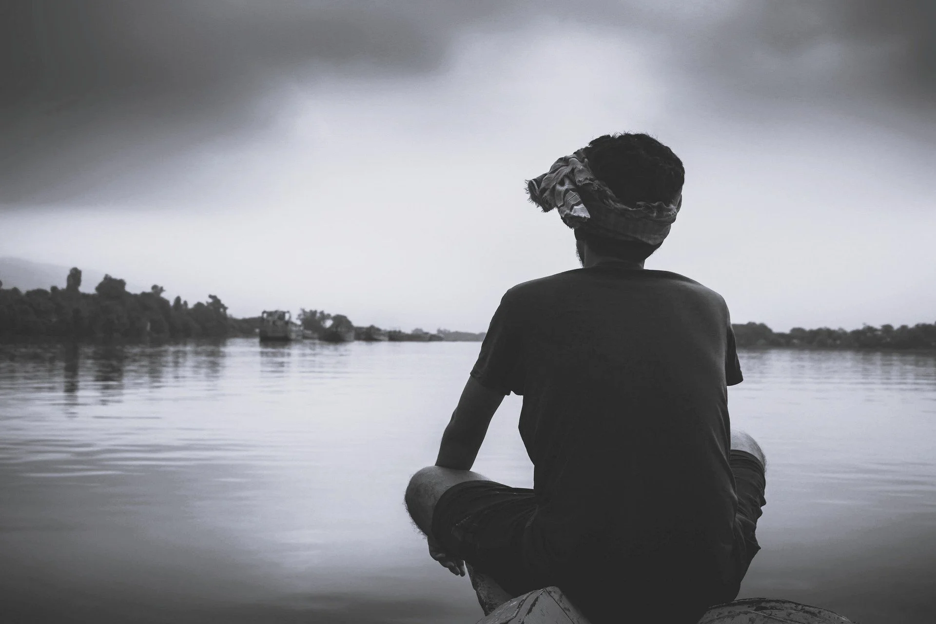 Person sitting alone at a lake