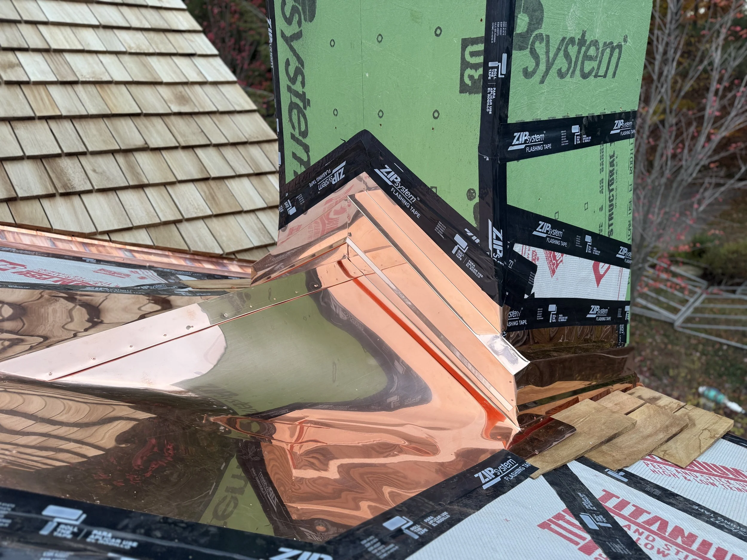 Custom hand-fabricated copper valley and chimney flashing tying into new cedar shake roof with ZIP System sheathing Walloon Lake Michigan