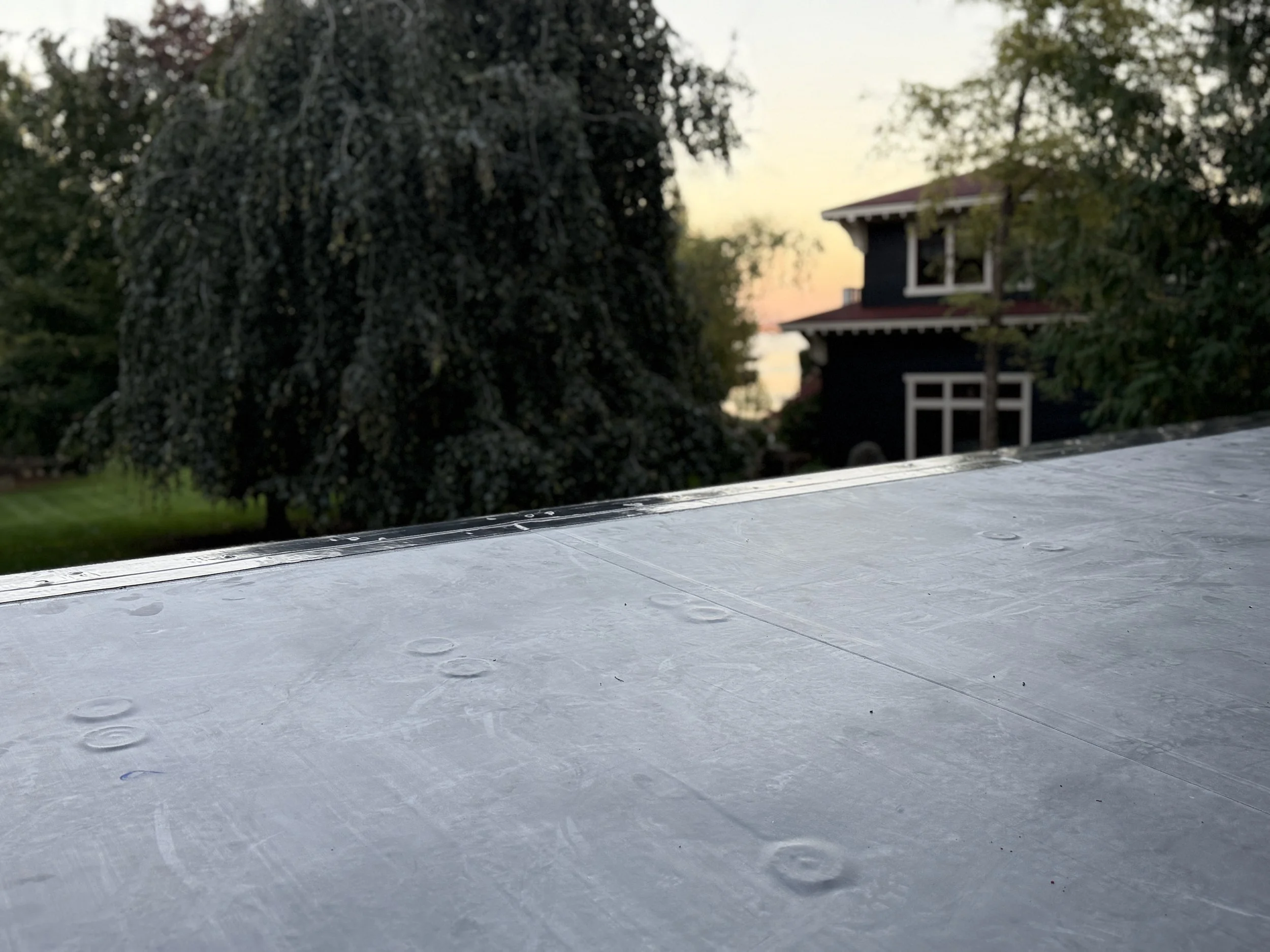 New low-slope EPDM Versico roofing membrane with clean seams and edge metal on flat roof overlooking lake Charlevoix