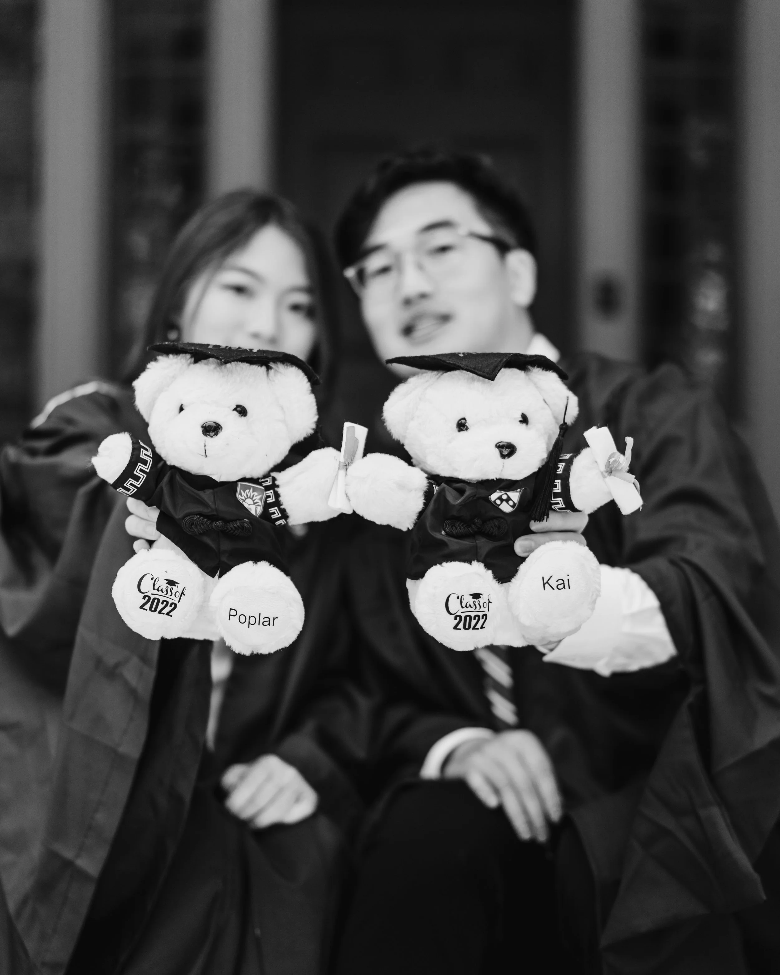 Two students holding teddy bears for graduation